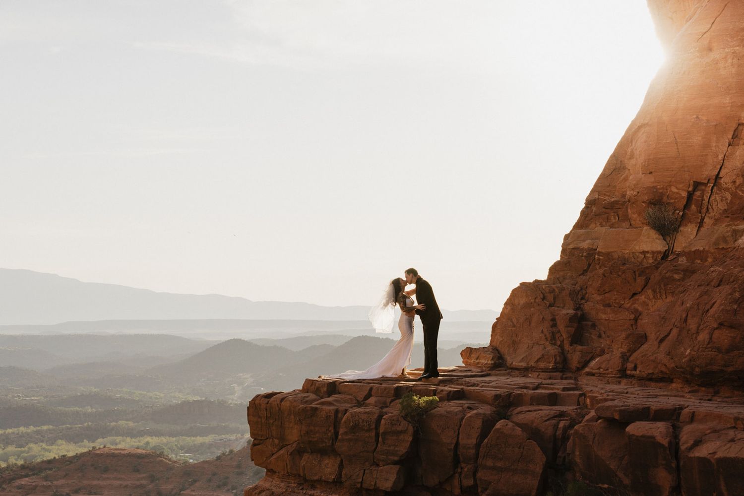 A panoramic view of red rock formations in a desert landscape stretches across multiple connected photos.