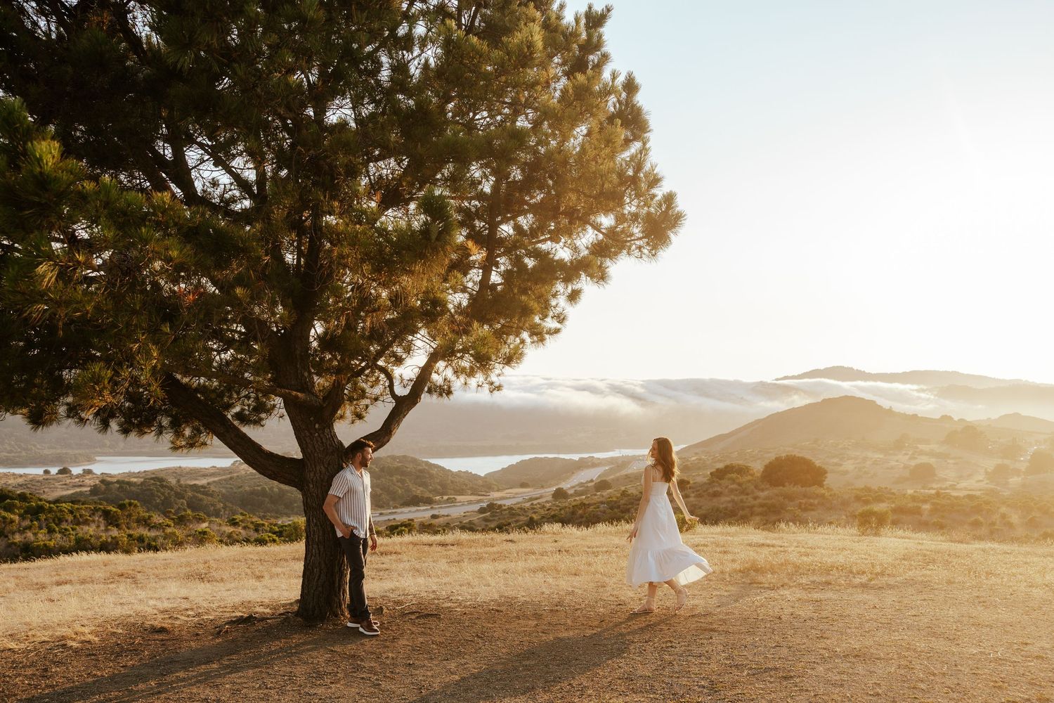 Bay Area engagement photoshoot at golden hour on a field overlooking a gorgeous view.