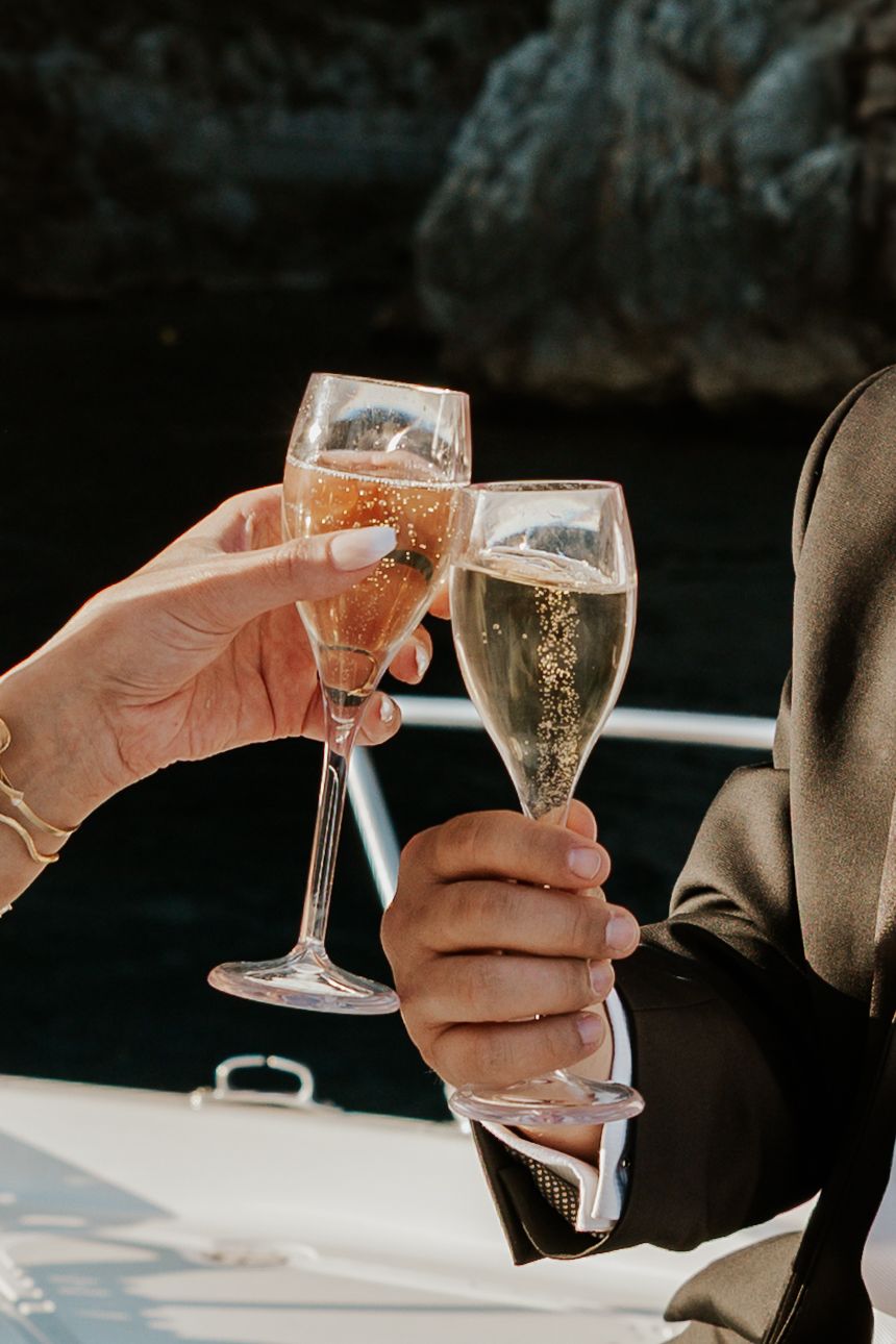 champagne glasses clinking while the sun hits along the amalfi coast from positano elopement photographer