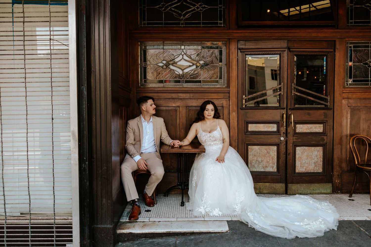 couple sitting in front of a restaurant in san francisco on their elopement day
