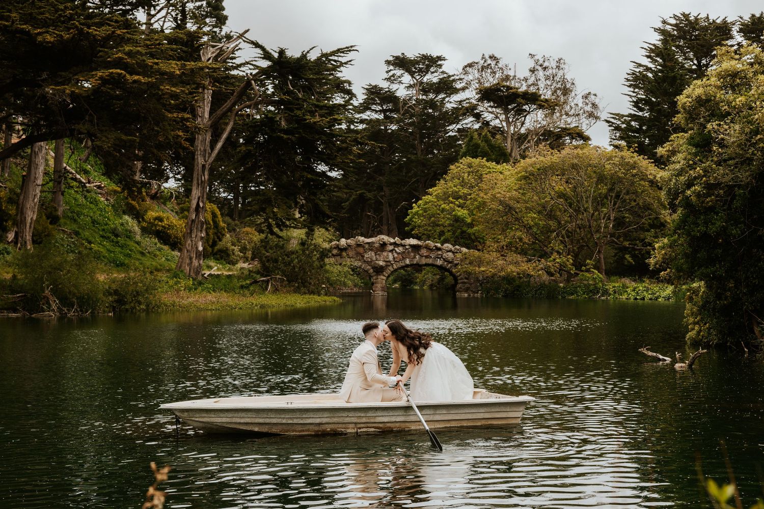 san francisco bay area elopement photographer captures authentic and romantic photos in golden gate park while couple is kissing in row boat