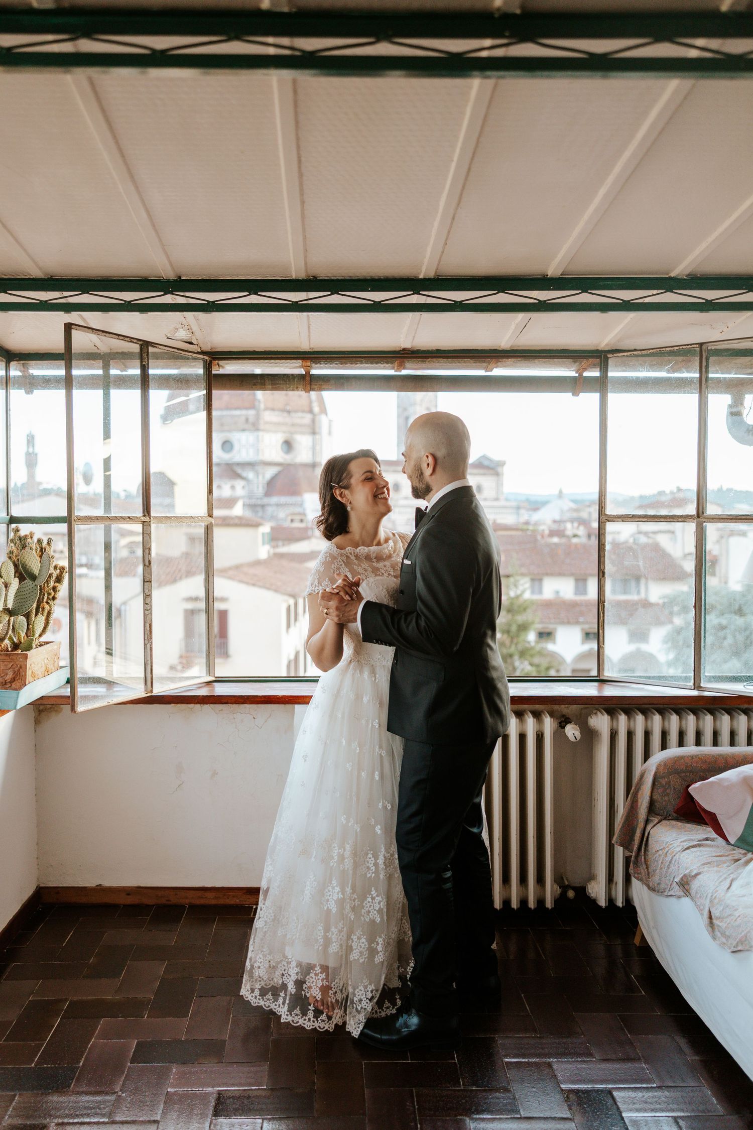 couple dancing in florence airbnb with view of Duomo on their adventure all day elopement in tuscany, italy