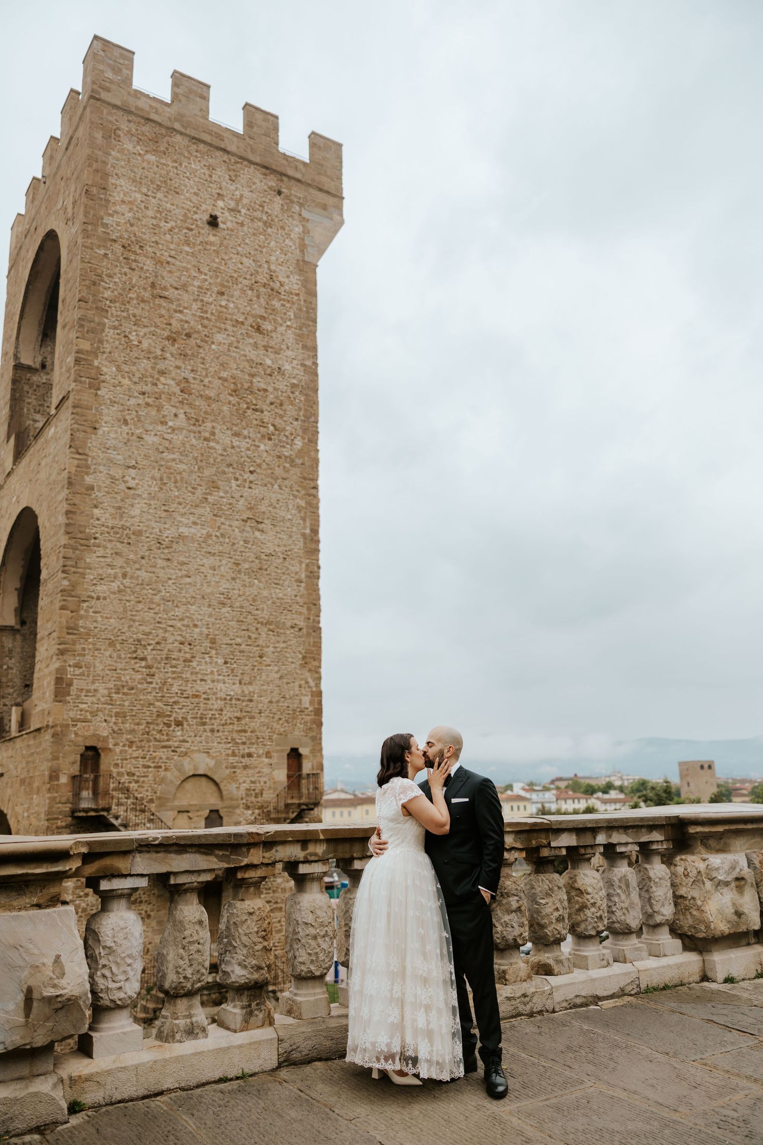 candid couple kissing in San Gimignano on their all day elopement in tuscany, italy