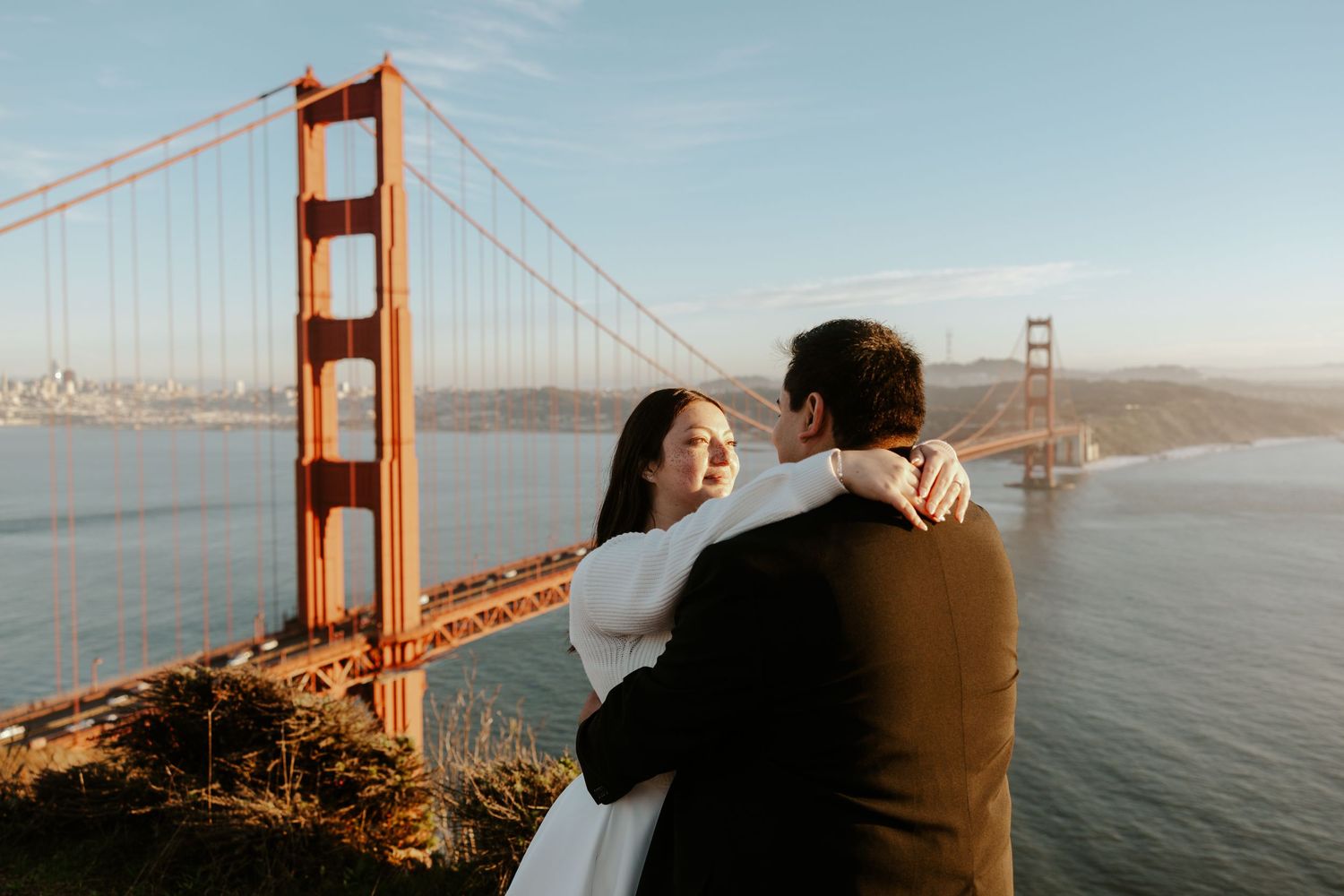 bride and groom looking at each other with the Golden Gate Bridge in the background on their San Francisco elopement day