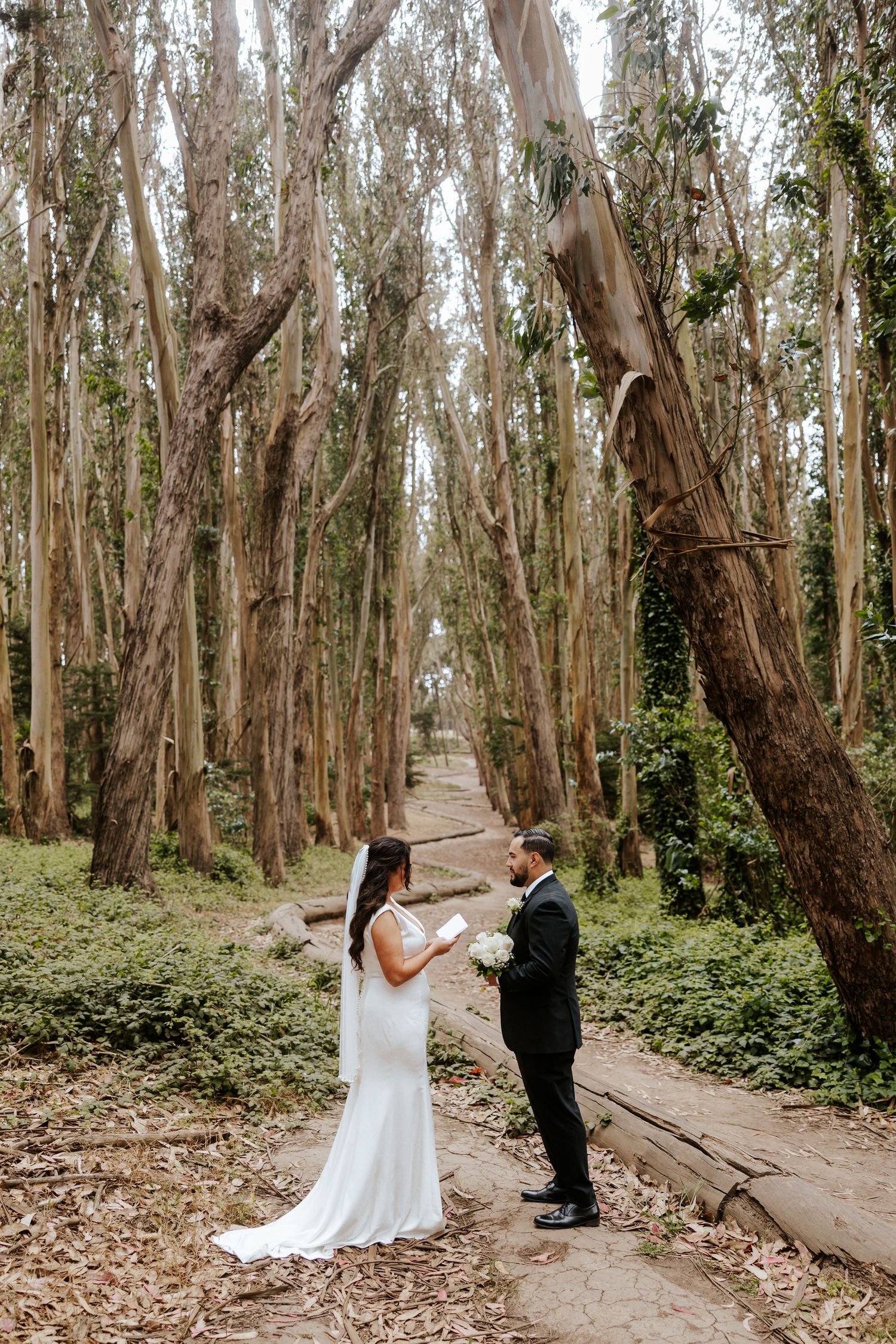 bride reading her vows to groom at lover's lane tree grove in san francisco on their elopement day