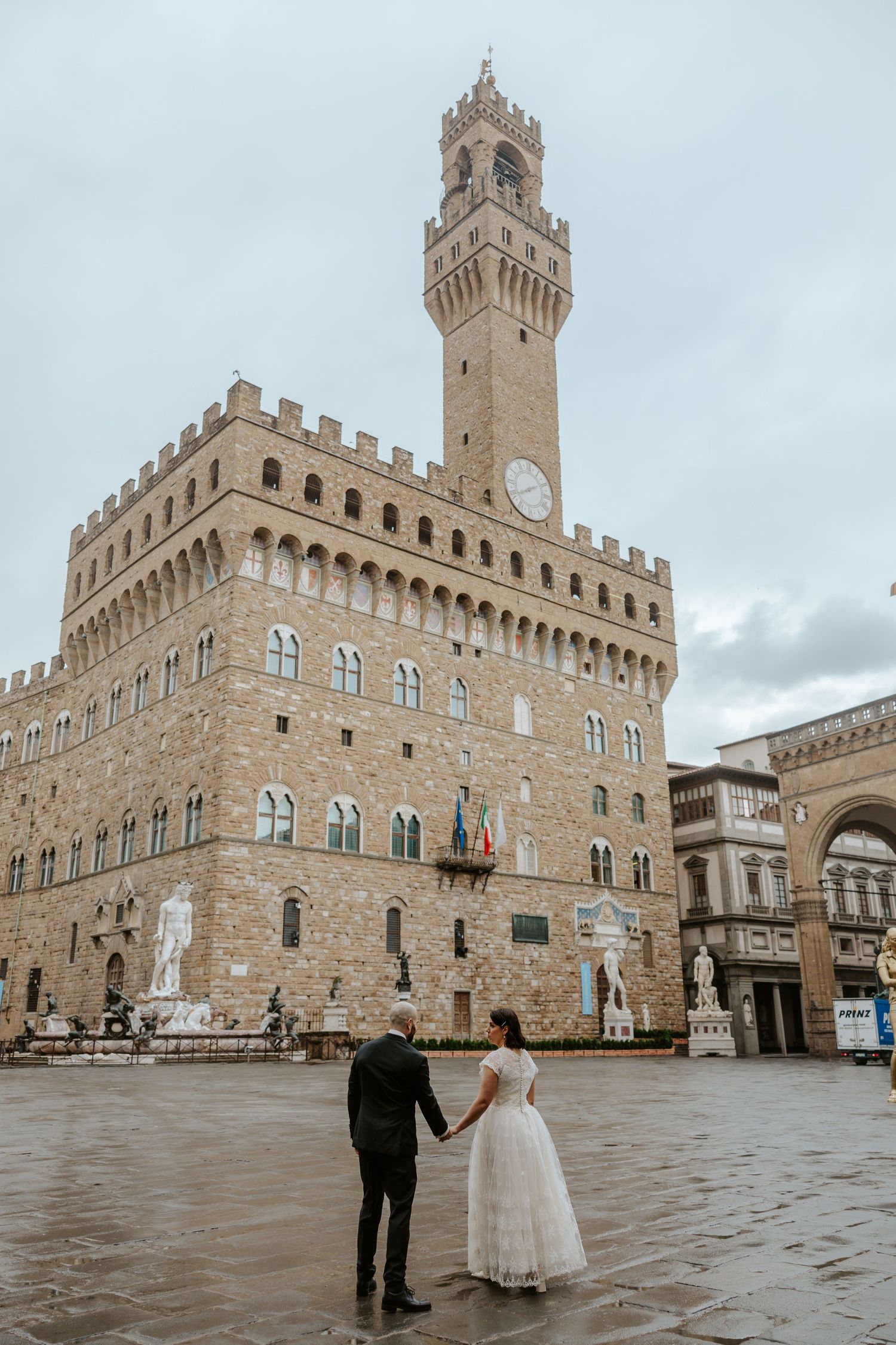 couple running around the town of San Gimignano on their tuscany elopement day