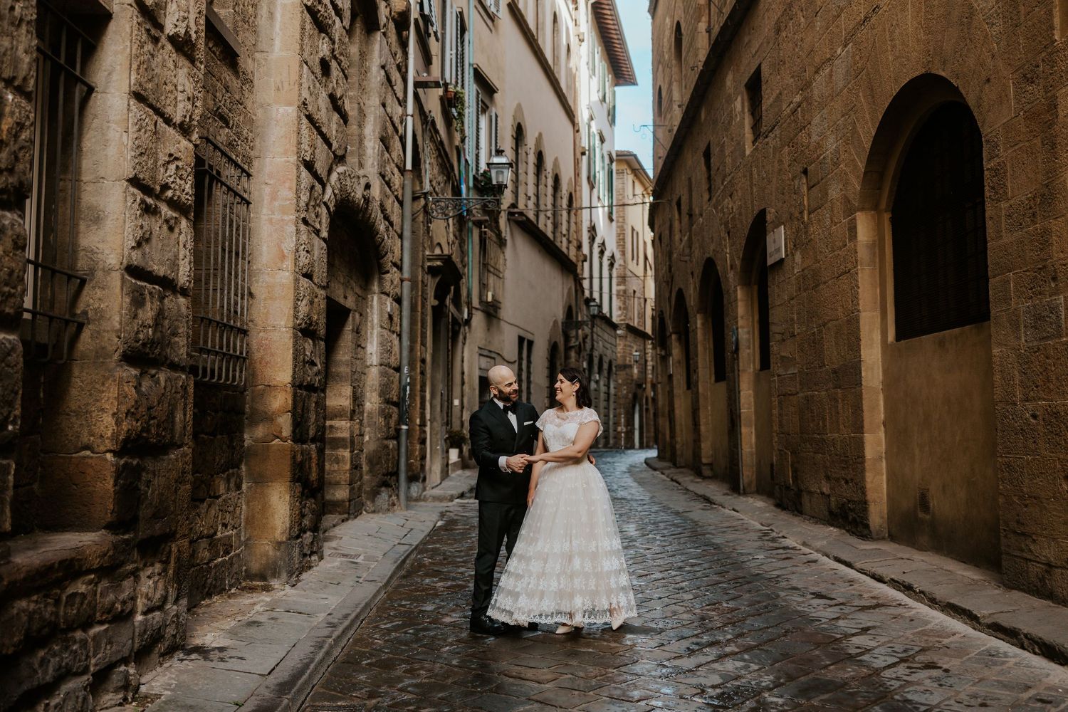 couple candidly strolling through the streets in florence, italy on their all day adventure tuscany elopement