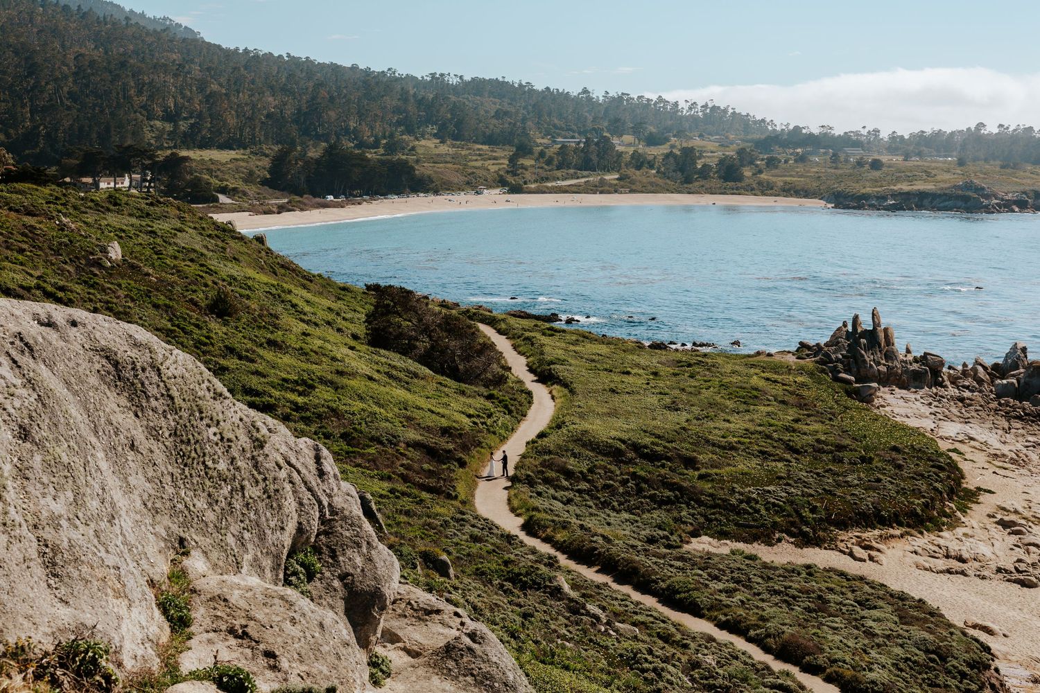 couple walking along a coastal trail in carmel