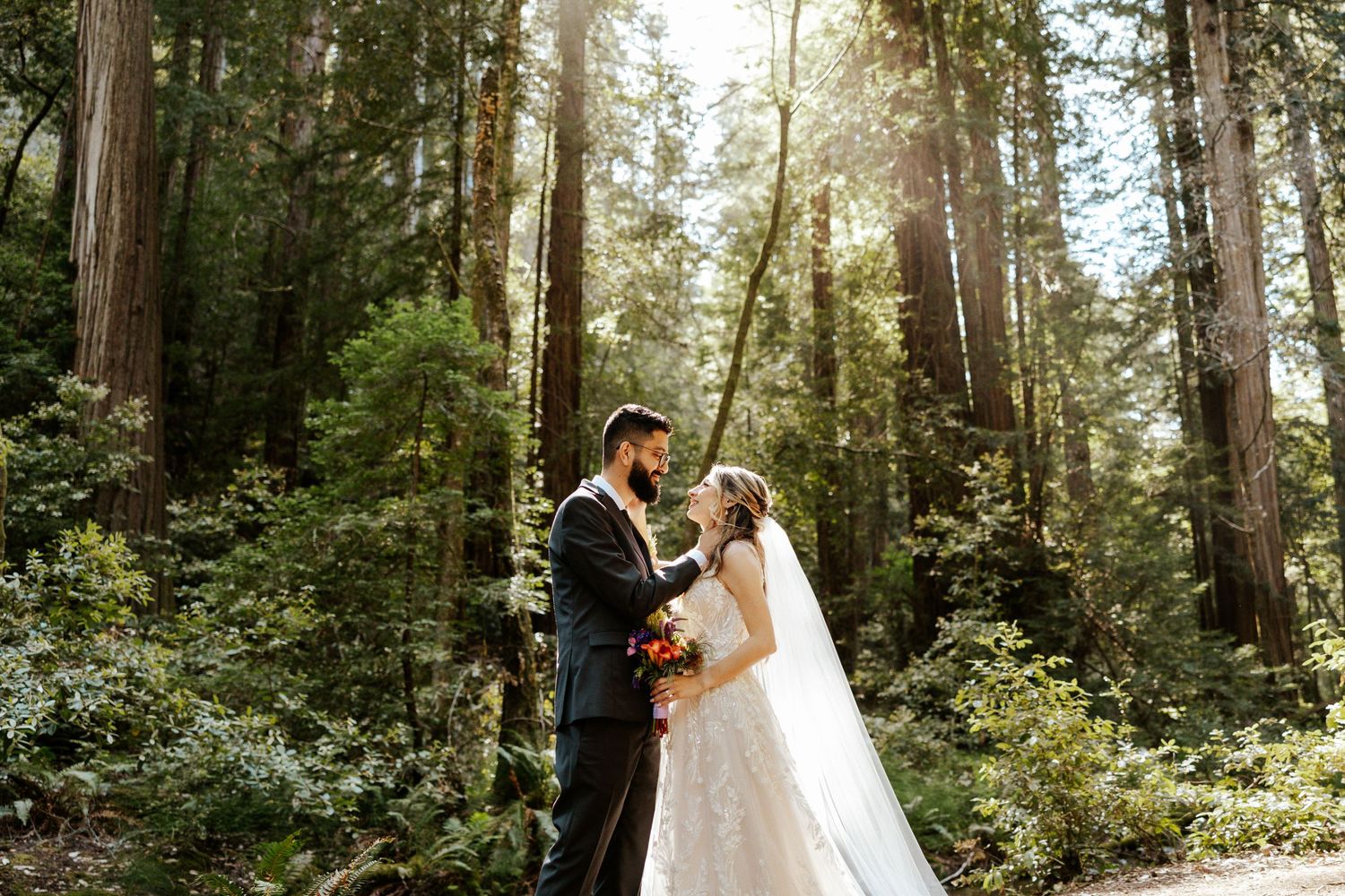 bride and groom looking at each other with the sun shining through the redwoods during their muir woods elopement day