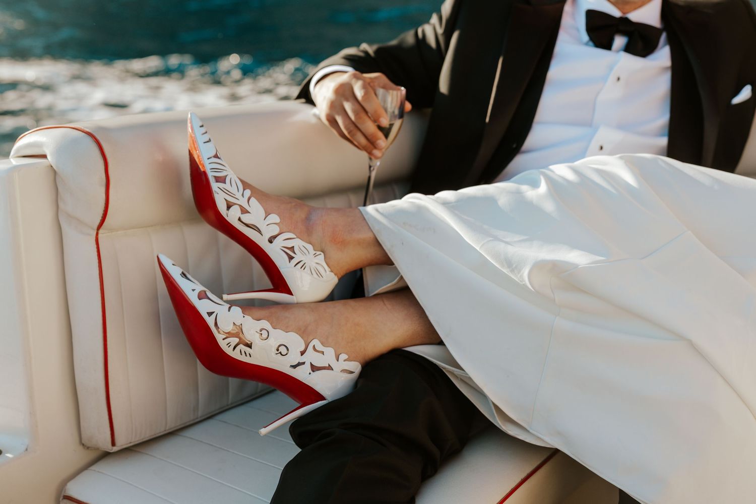 bride showing off her louboutin while sitting on a boat in italy during positano elopement day