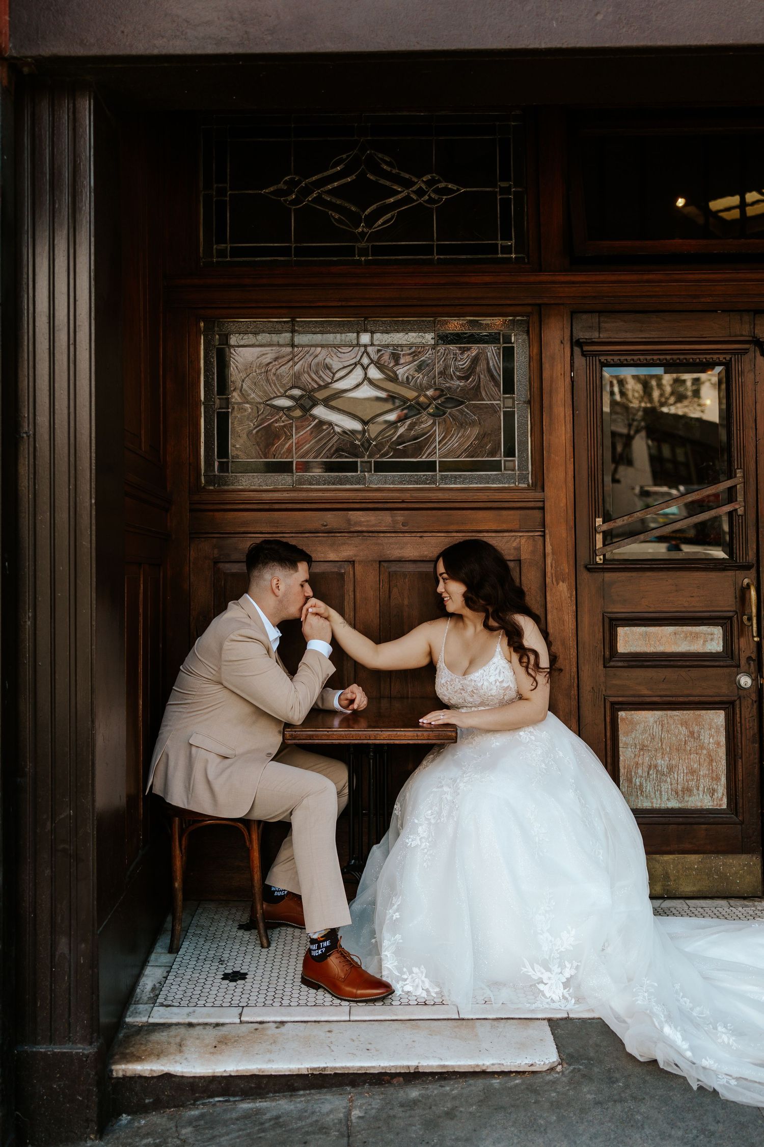 couple sitting in front of a restaurant in san francisco on their elopement day. authentic and romantic elopement photos in the bay area