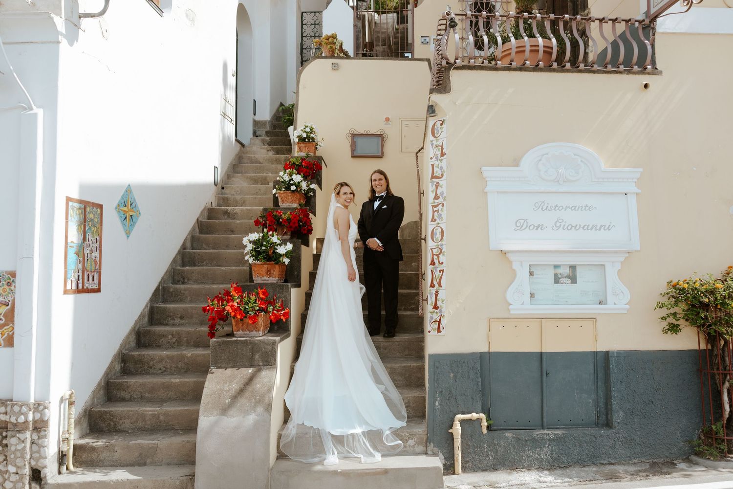bride and groom standing on staircase during positano elopement photos