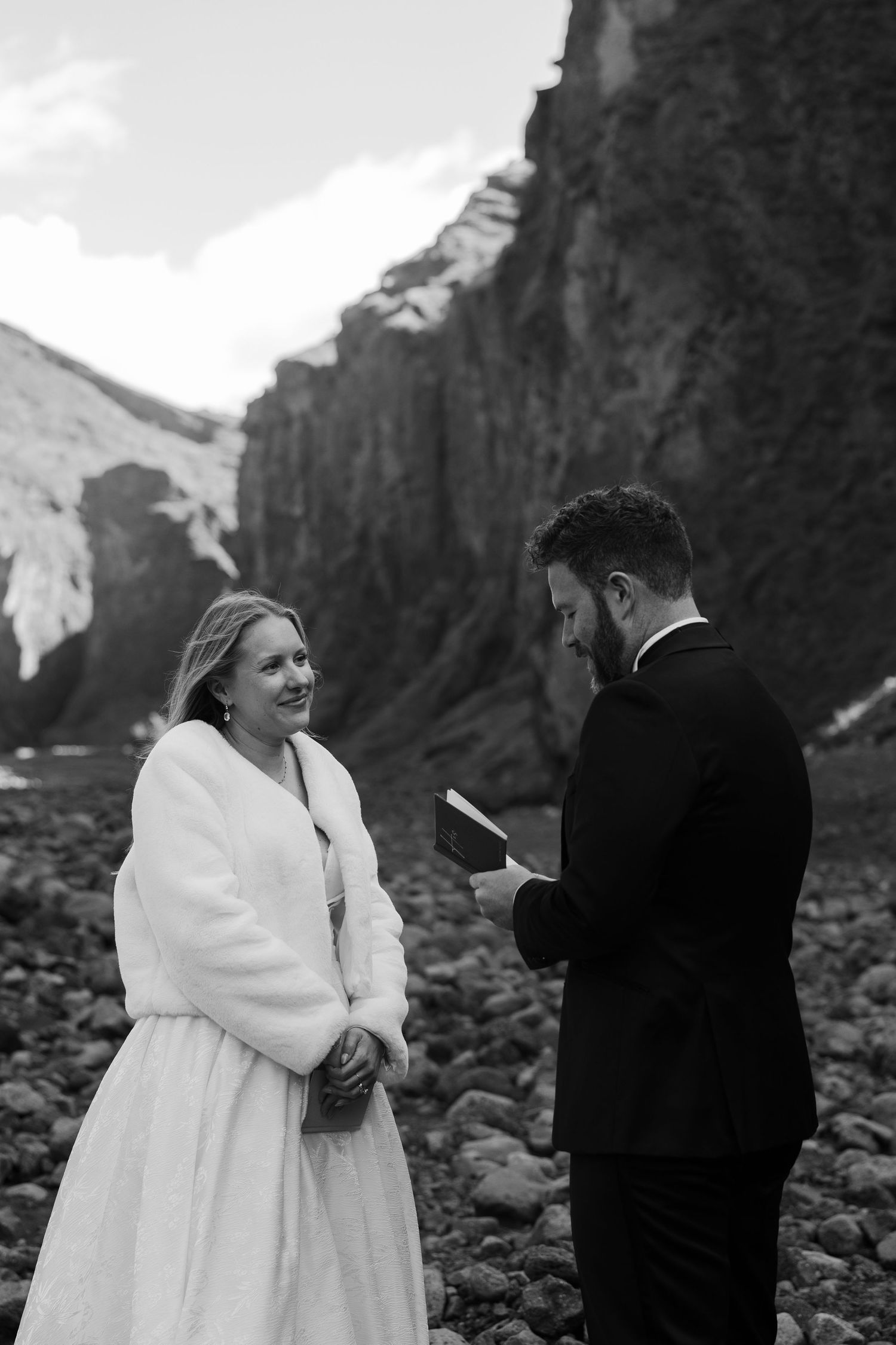 black and white photo of groom sharing vows to his bride in iceland