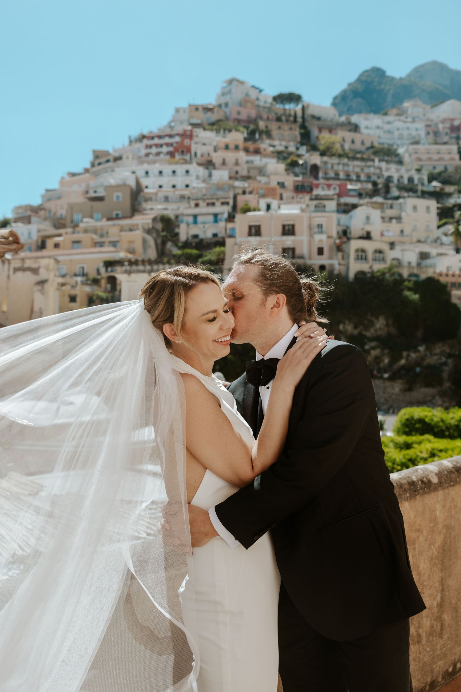 groom kissing bride's cheek on a secret staircase in Positano during Amalfi Coast elopement day