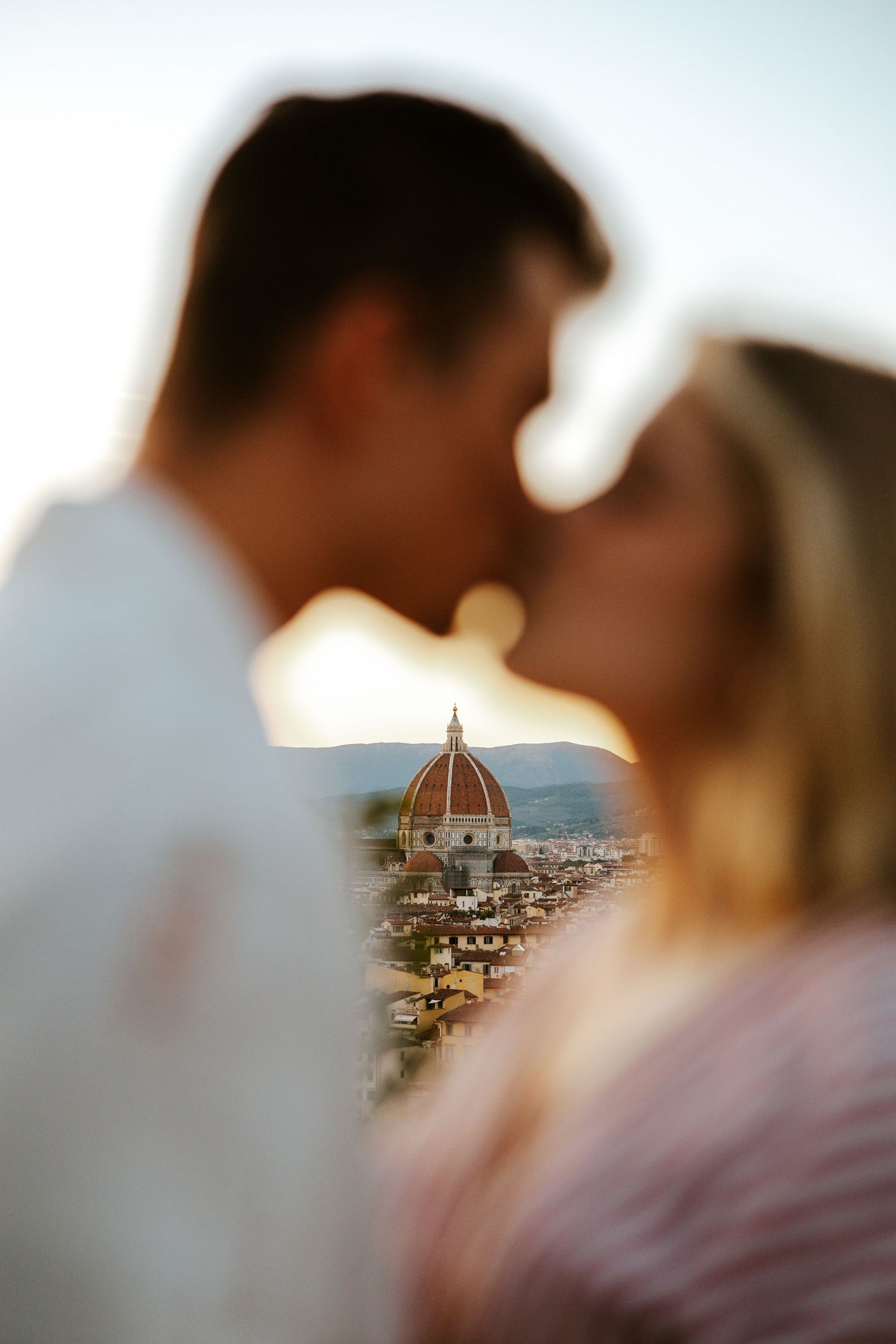 view of Duomo from Piazzale Michelangelo with a couple kissing during sunset on their elopement day in tuscany