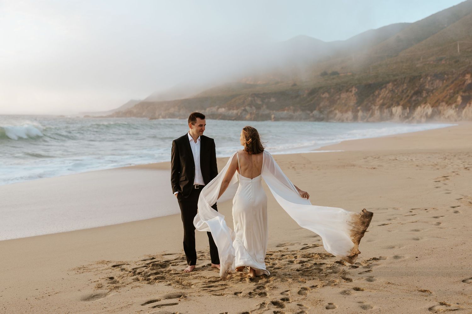 bride and groom running around the beach at sunset during carmel elopement