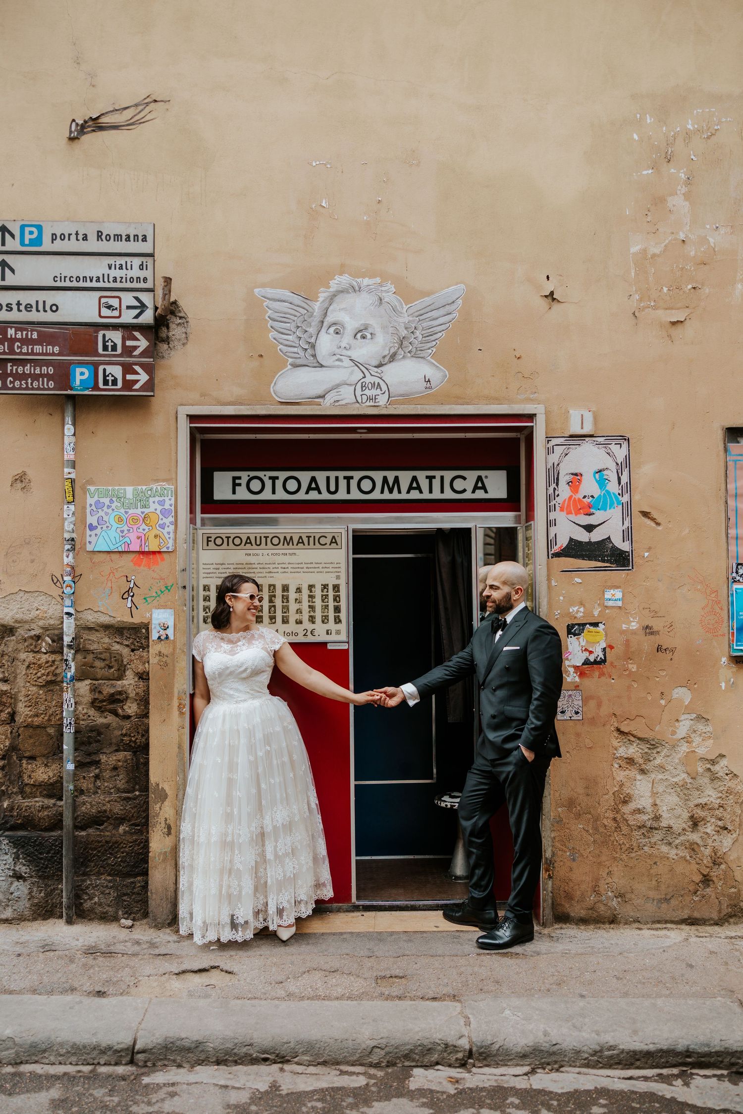 couple standing in front of Fotoautomatica photobooth in florence, italy during their all day adventure elopement in tuscany italy