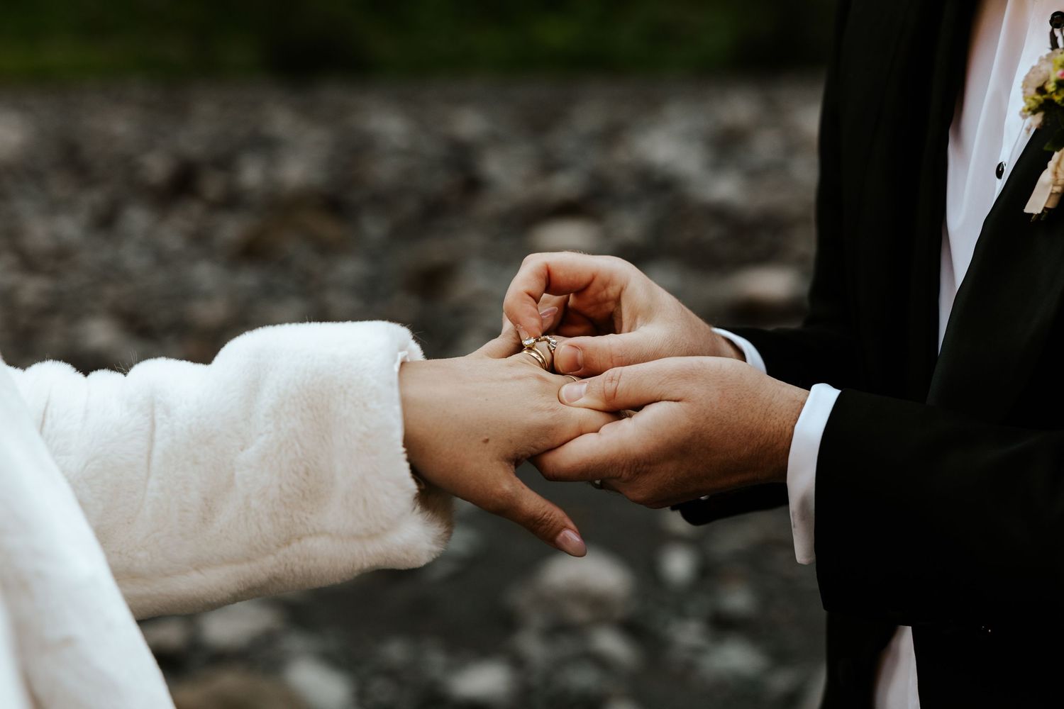close up detail shot of groom putting wedding ring on bride after vows during iceland elopement