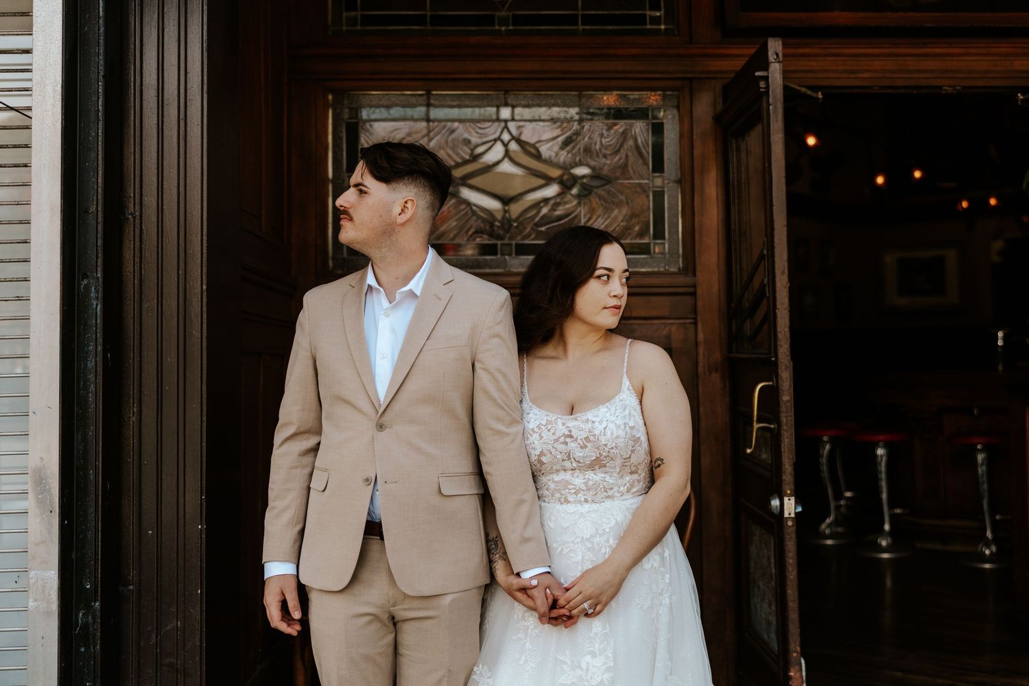 Couple standing in front of a bar after eloping in San Francisco