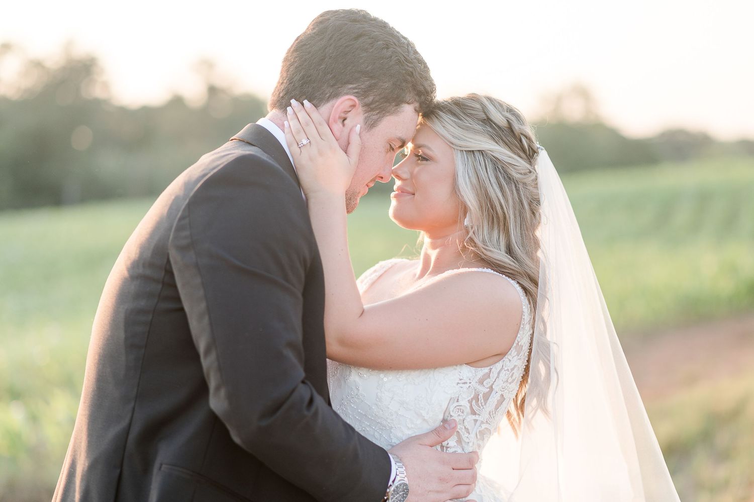 Bride and groom embrace at sunset