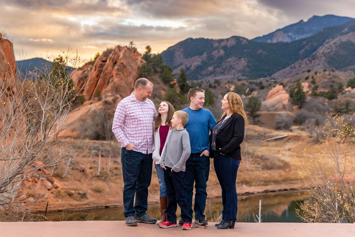 Group enjoying sunset against dramatic red rock formations at Garden of the Gods in Colorado Springs during golden hour.