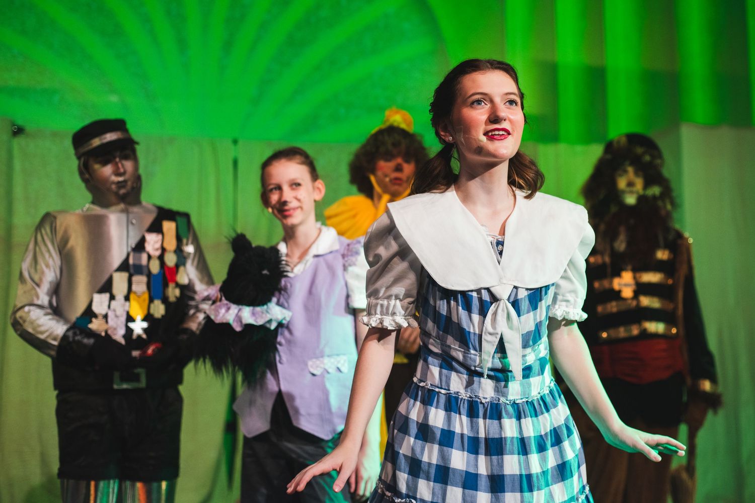 A photo from a production of the Wizard of Oz, the actress playing Dorothy is in the front with the rest of the Fab Five behind her.