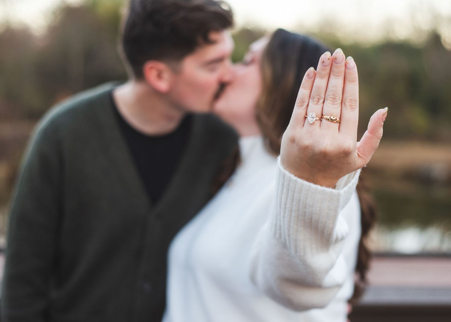 A newly engaged couple kissing.