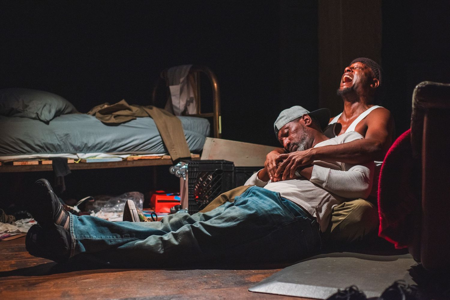 A photo from a production of Topdog/Underdog. The actors are together on the floor.