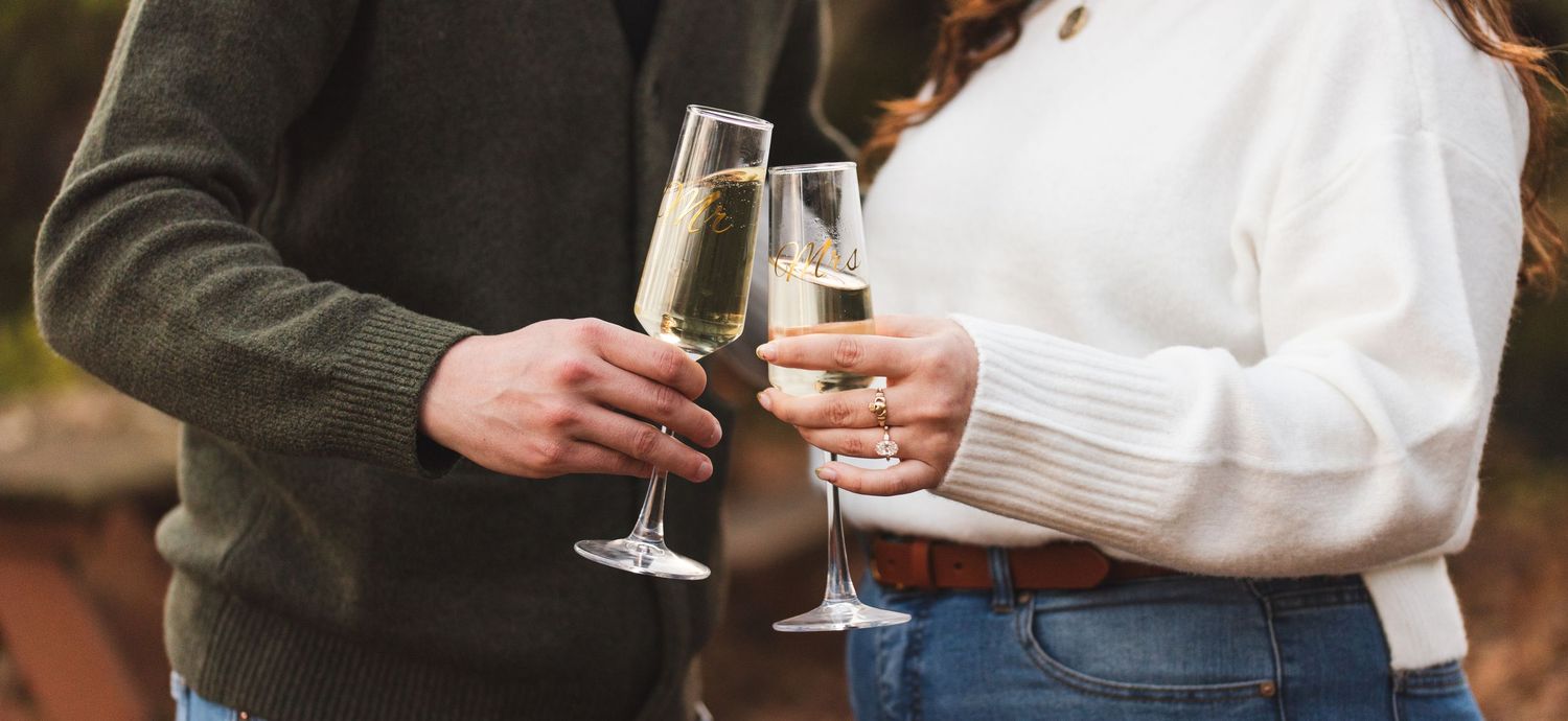 A newly engaged couple toasting champagne glasses.