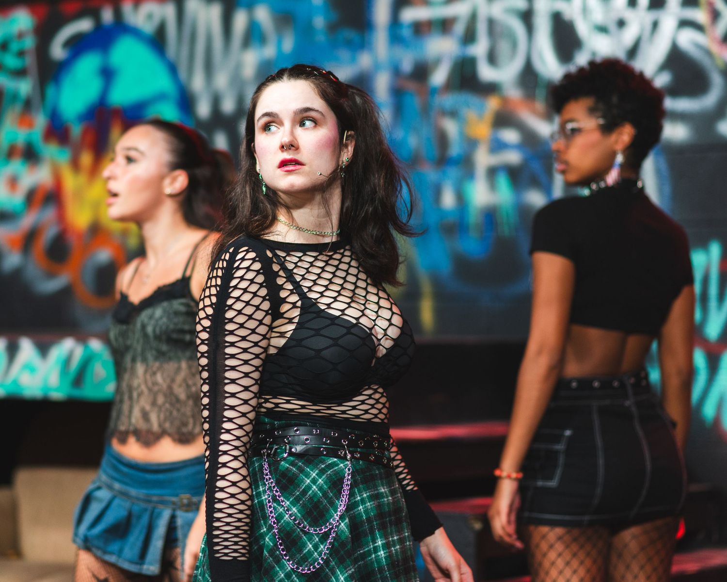 A photo from a production of American Idiot. Three actresses are featured.