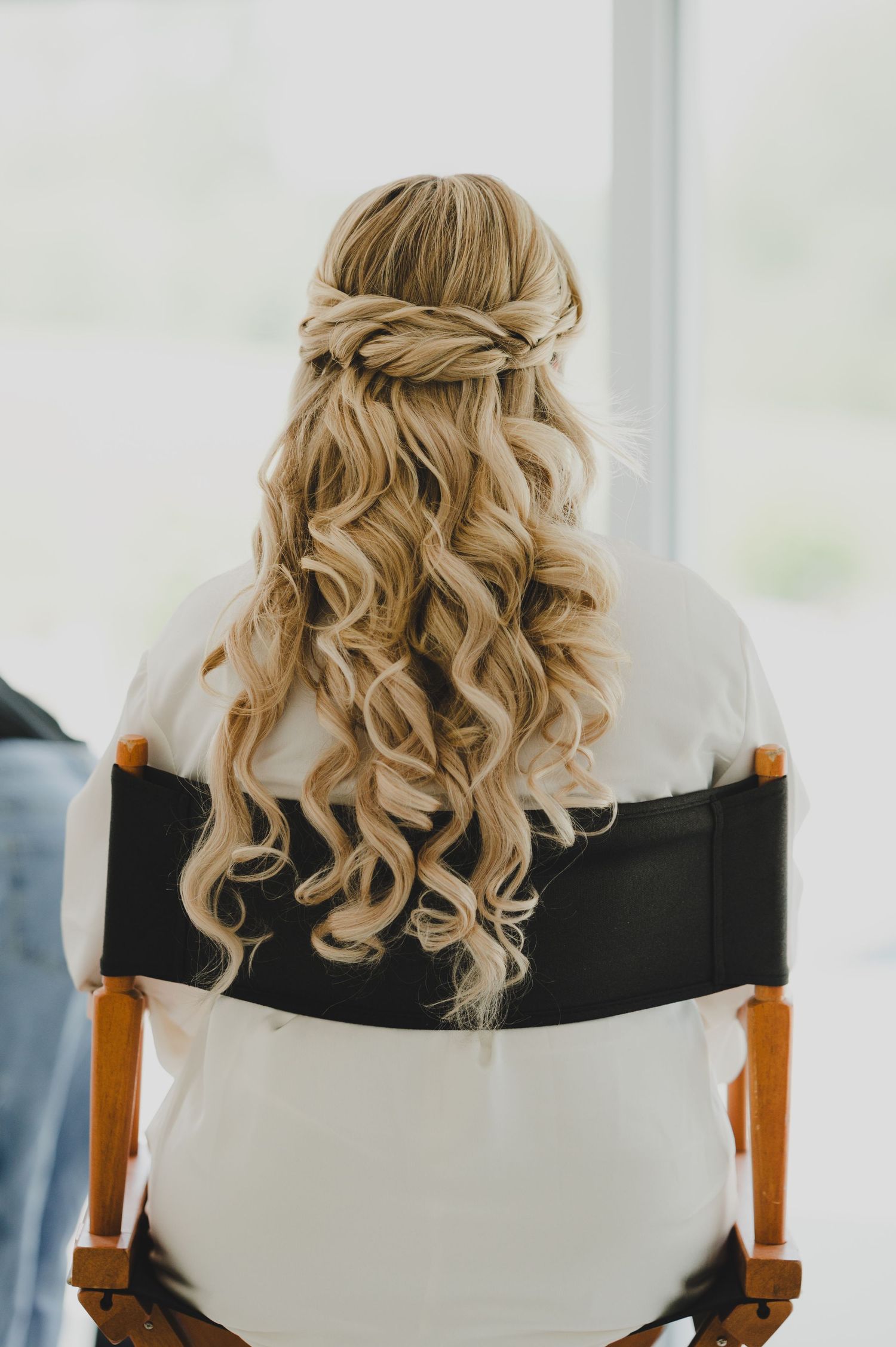Back view of elegant bridal hairstyle with blonde curls and braided crown details shown from multiple angles.