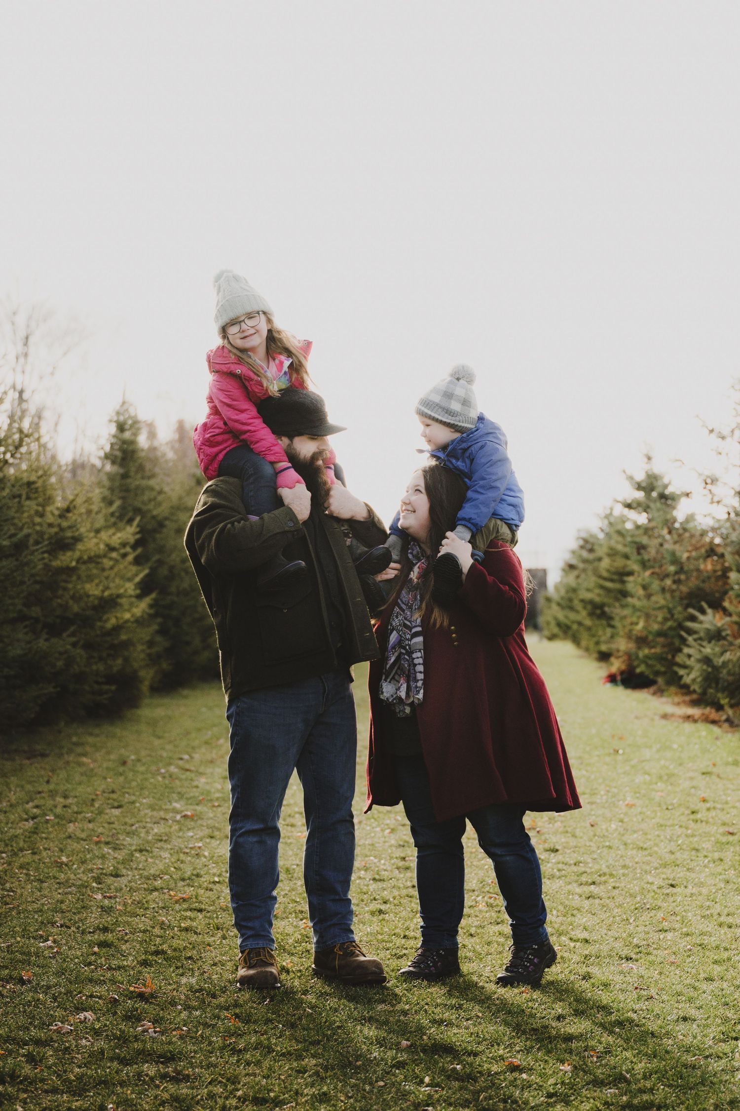 Family spending time together at a Christmas tree farm on a fall afternoon.