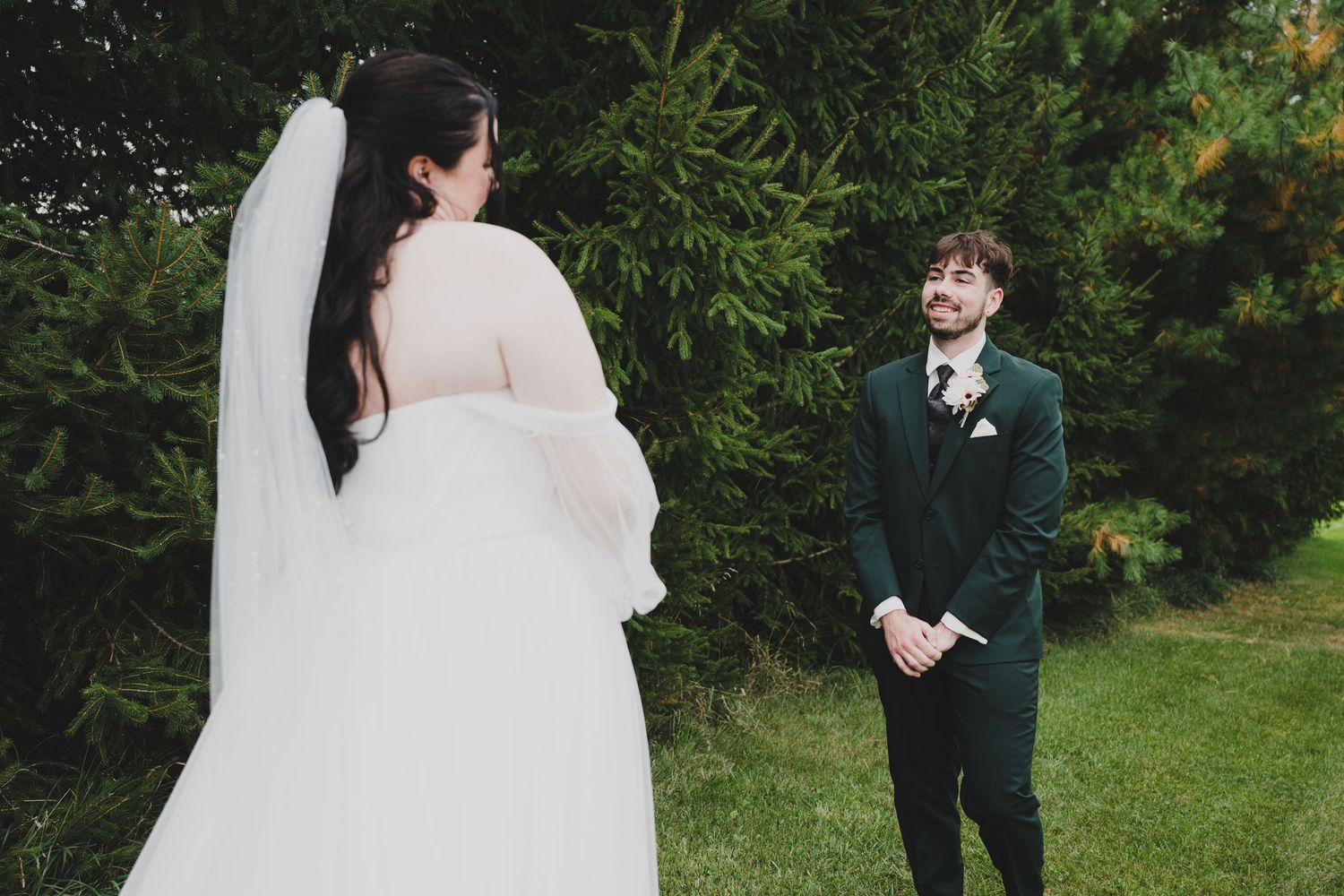 A couple shares a joyful moment during their outdoor garden wedding ceremony.