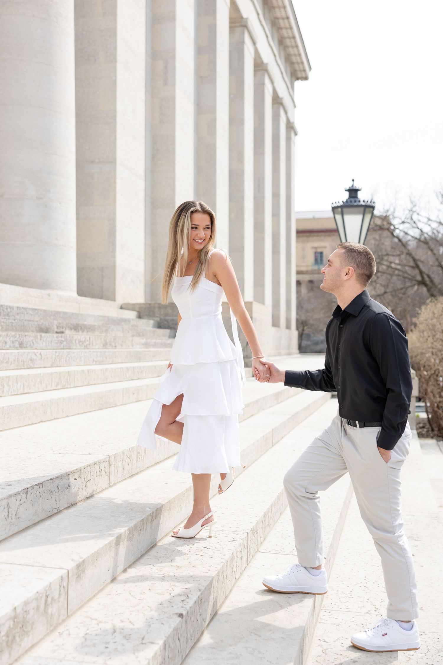 Light and airy engagement photos of a joyful couple at the Ohio Statehouse in downtown Columbus, Ohio captured by Julia and Sean Photography