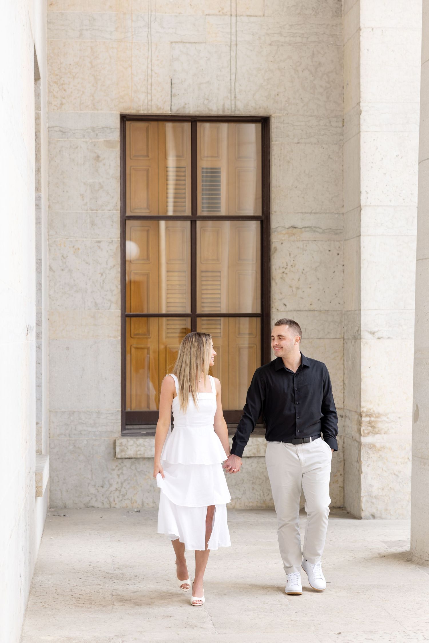 Light and airy engagement photos of a joyful couple at the Ohio Statehouse in downtown Columbus, Ohio captured by Julia and Sean Photography