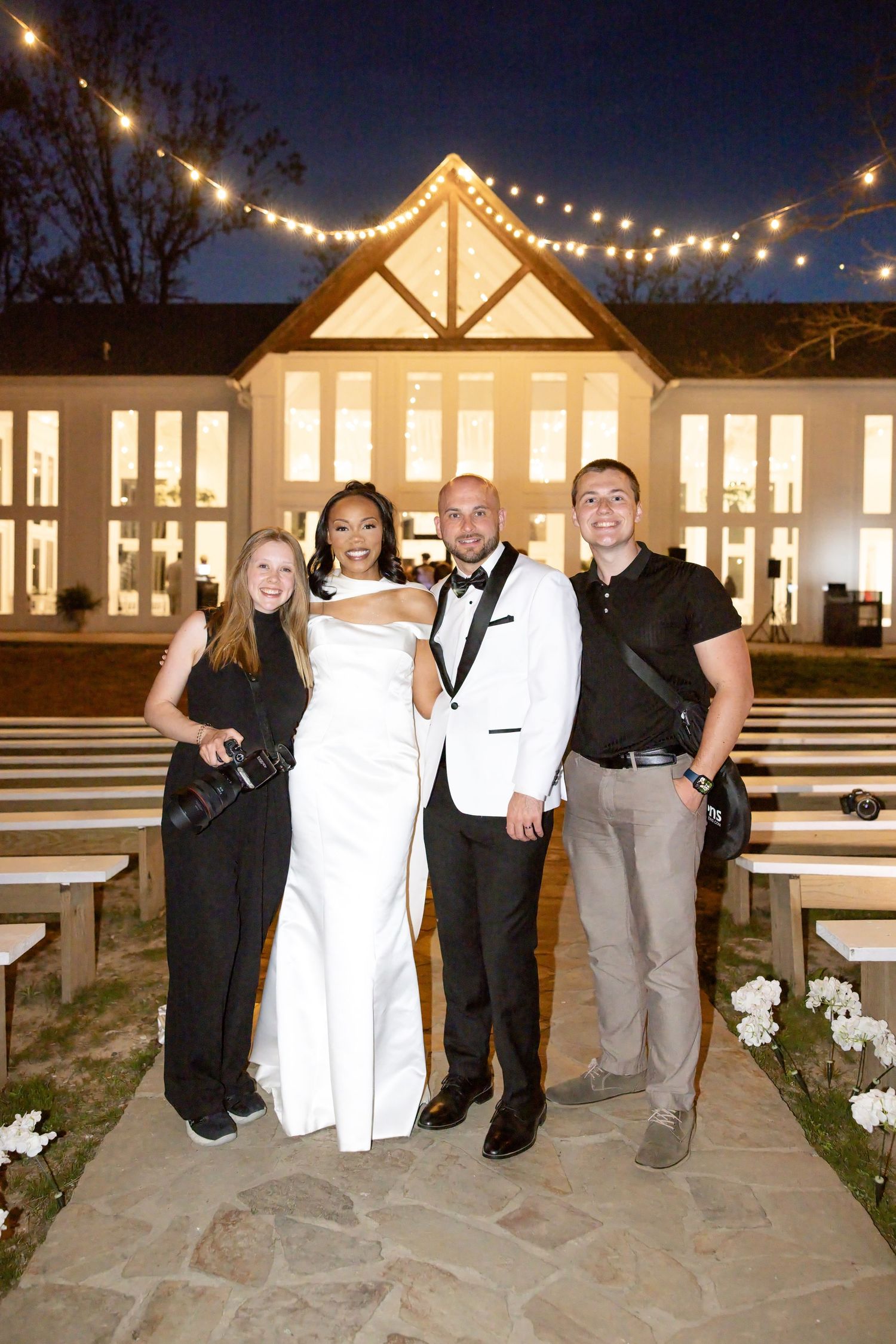 Husband and wife wedding photographers celebrating with bride and groom at The Glass House near Huntsville, Alabama after a joyful wedding