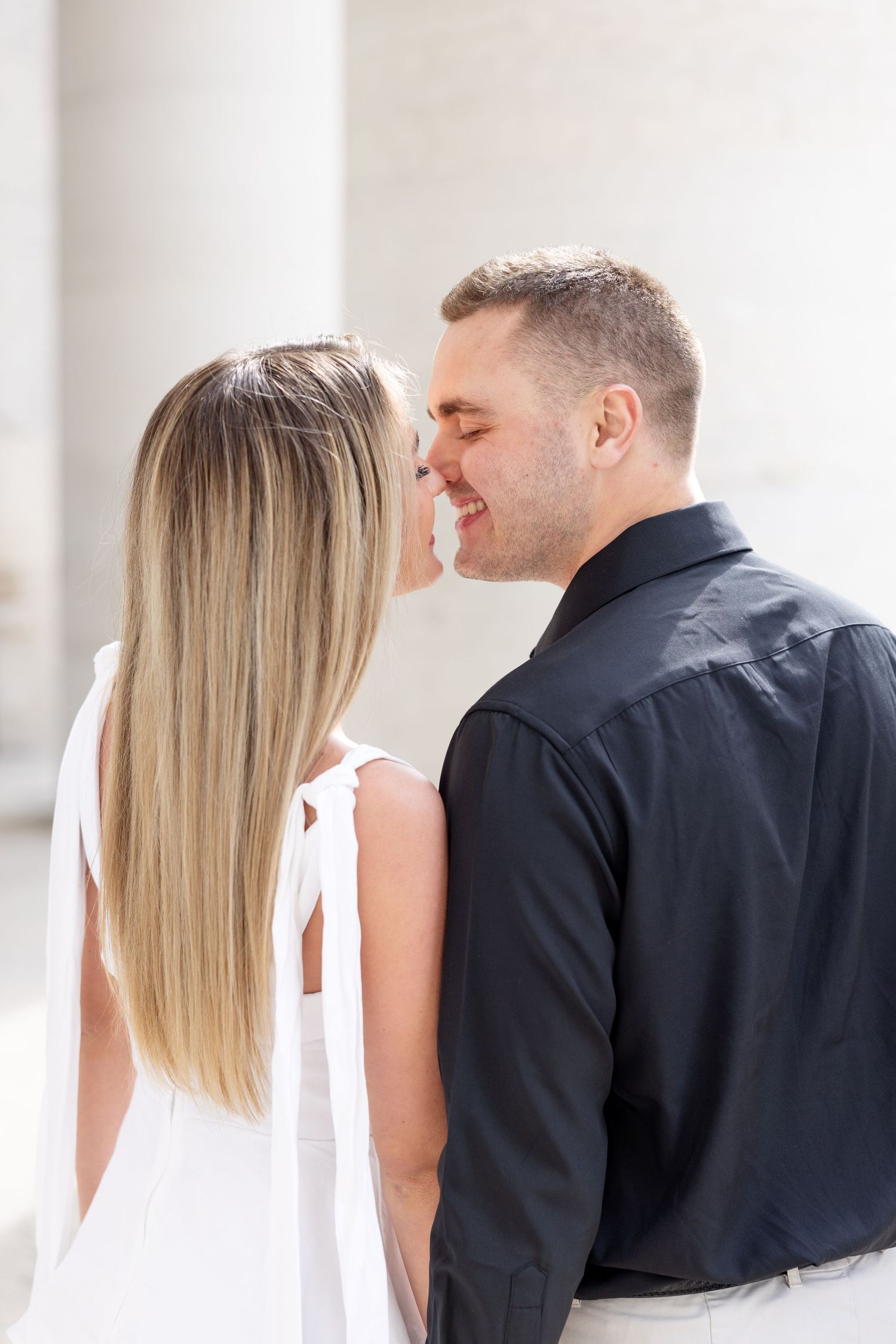 Light and airy engagement photos of a joyful couple at the Ohio Statehouse in downtown Columbus, Ohio captured by Julia and Sean Photography