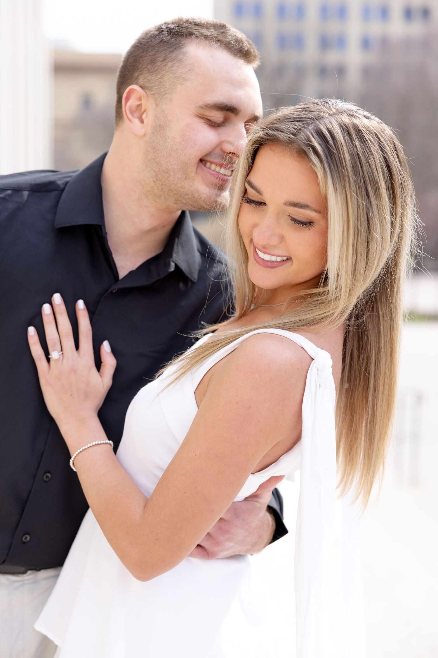 Light and airy engagement photos of a joyful couple at the Ohio Statehouse in downtown Columbus, Ohio captured by Julia and Sean Photography