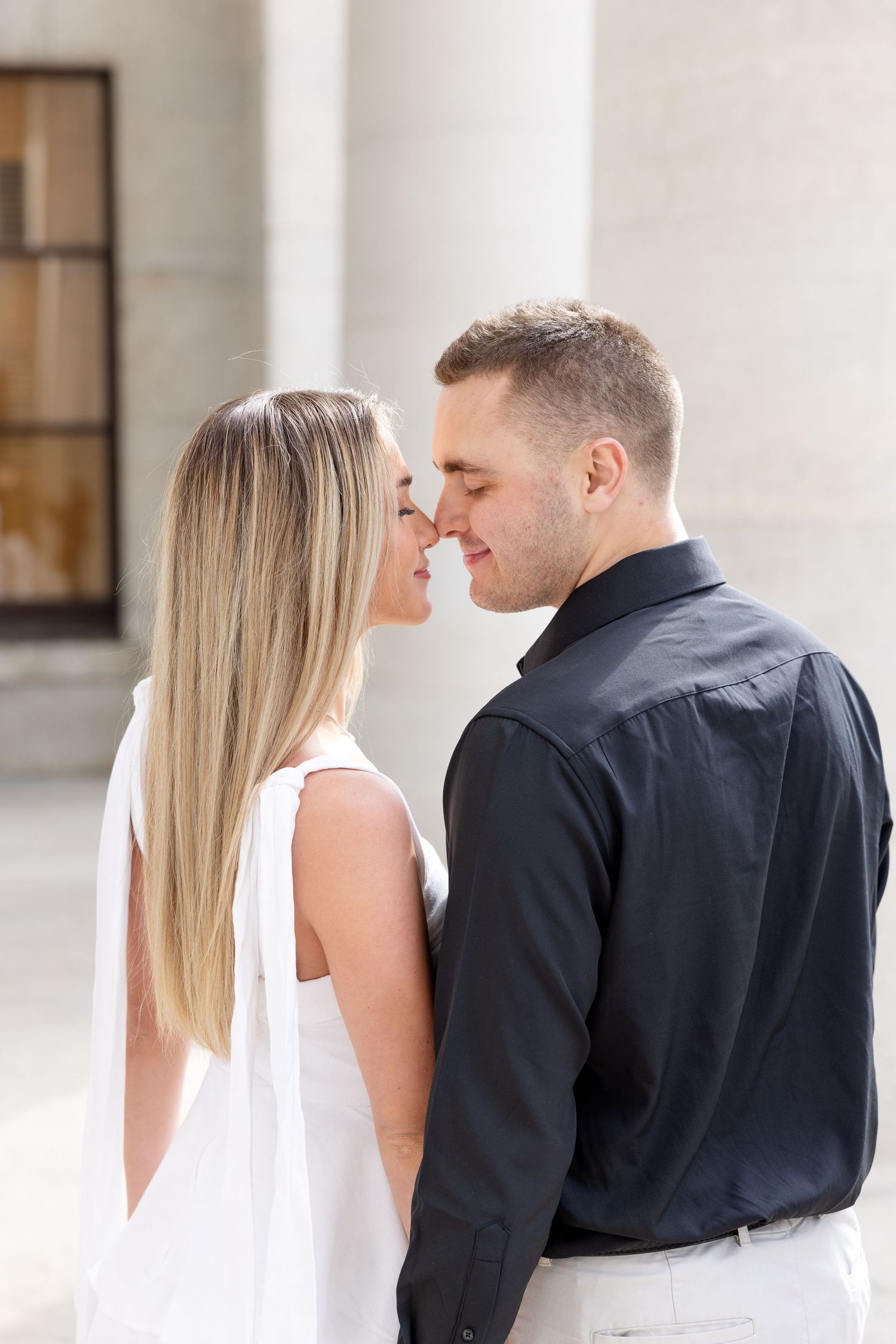 Light and airy engagement photos of a joyful couple at the Ohio Statehouse in downtown Columbus, Ohio captured by Julia and Sean Photography