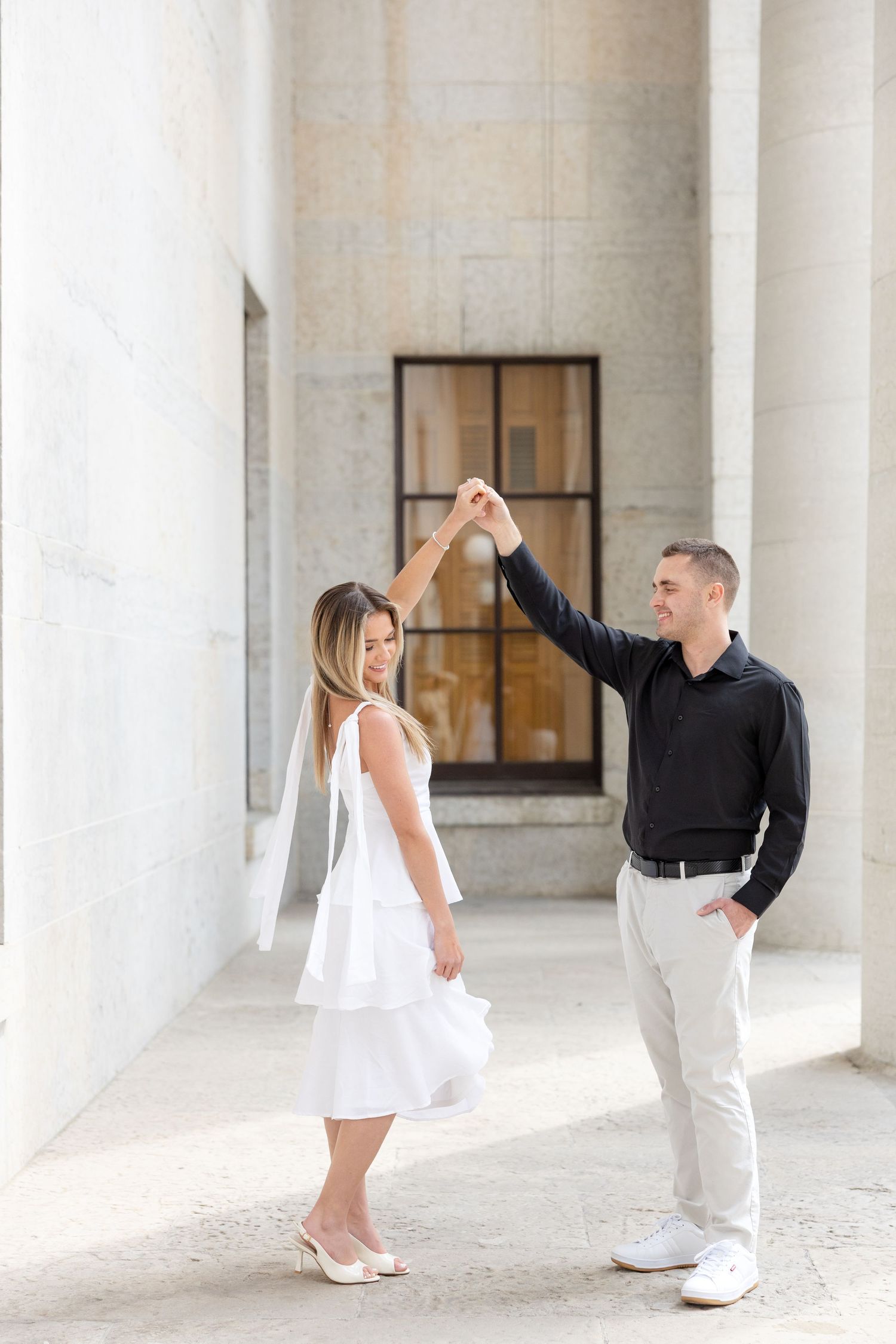Light and airy engagement photos of a joyful couple at the Ohio Statehouse in downtown Columbus, Ohio captured by Julia and Sean Photography