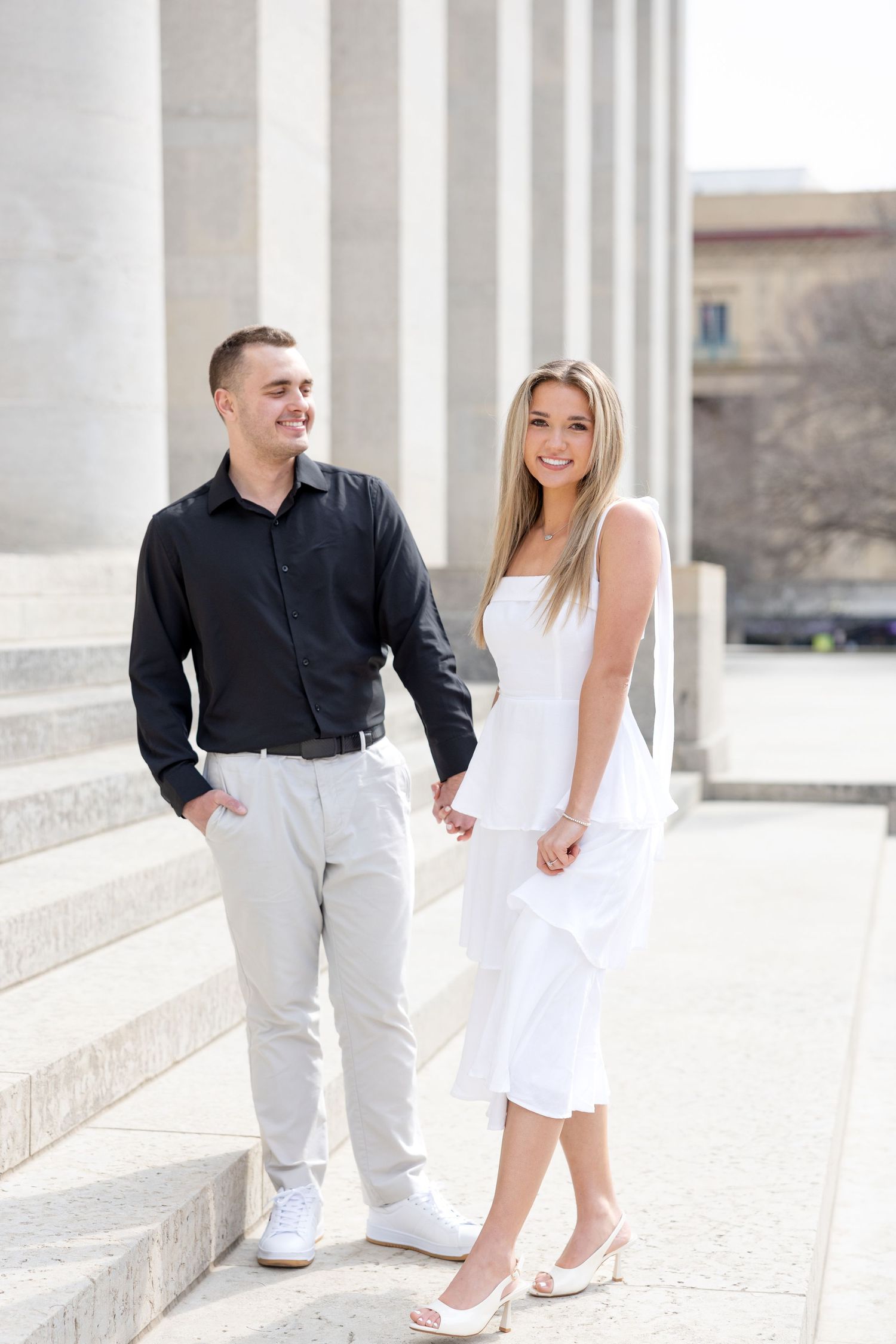 Light and airy engagement photos of a joyful couple at the Ohio Statehouse in downtown Columbus, Ohio captured by Julia and Sean Photography
