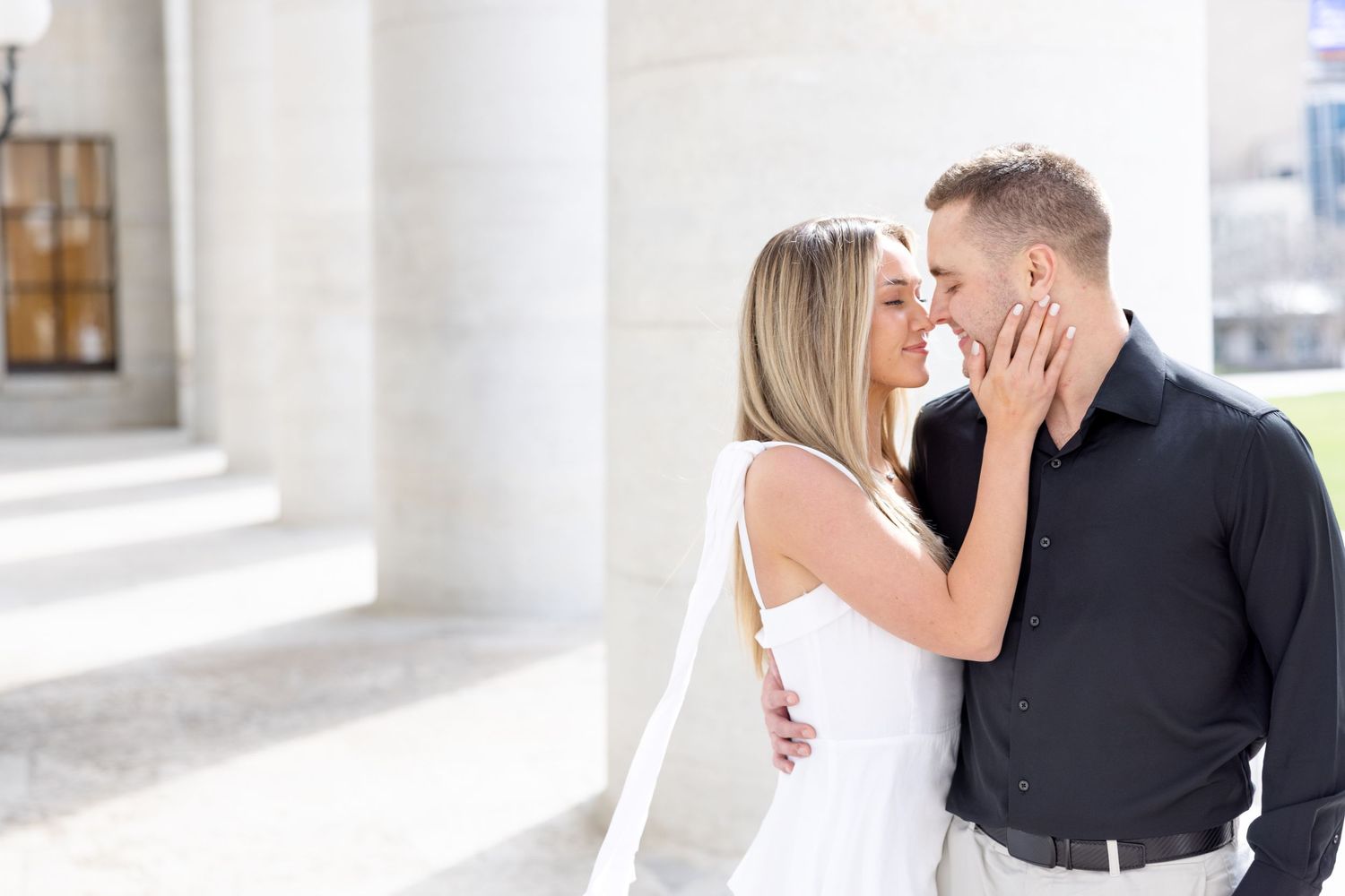 Light and airy engagement photos of a joyful couple at the Ohio Statehouse in downtown Columbus, Ohio captured by Julia and Sean Photography