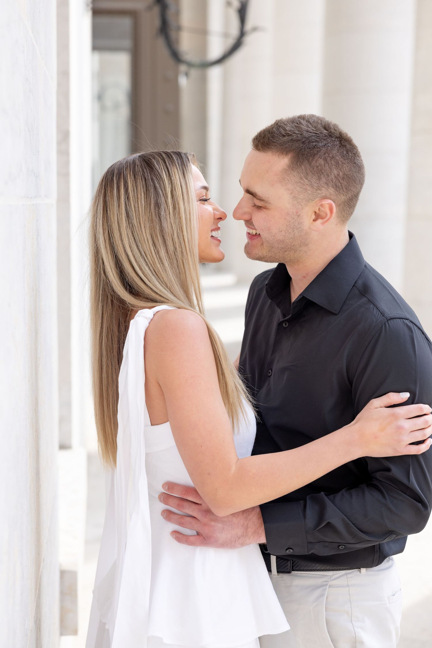 Light and airy engagement photos of a joyful couple at the Ohio Statehouse in downtown Columbus, Ohio captured by Julia and Sean Photography