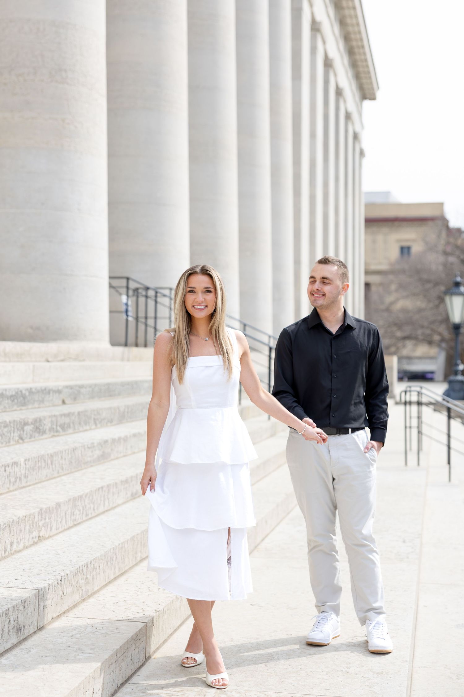 Light and airy engagement photos of a joyful couple at the Ohio Statehouse in downtown Columbus, Ohio captured by Julia and Sean Photography