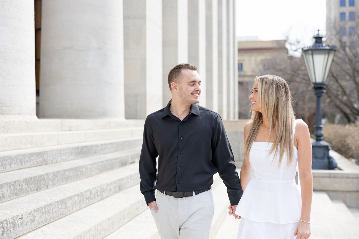 Light and airy engagement photos of a joyful couple at the Ohio Statehouse in downtown Columbus, Ohio captured by Julia and Sean Photography