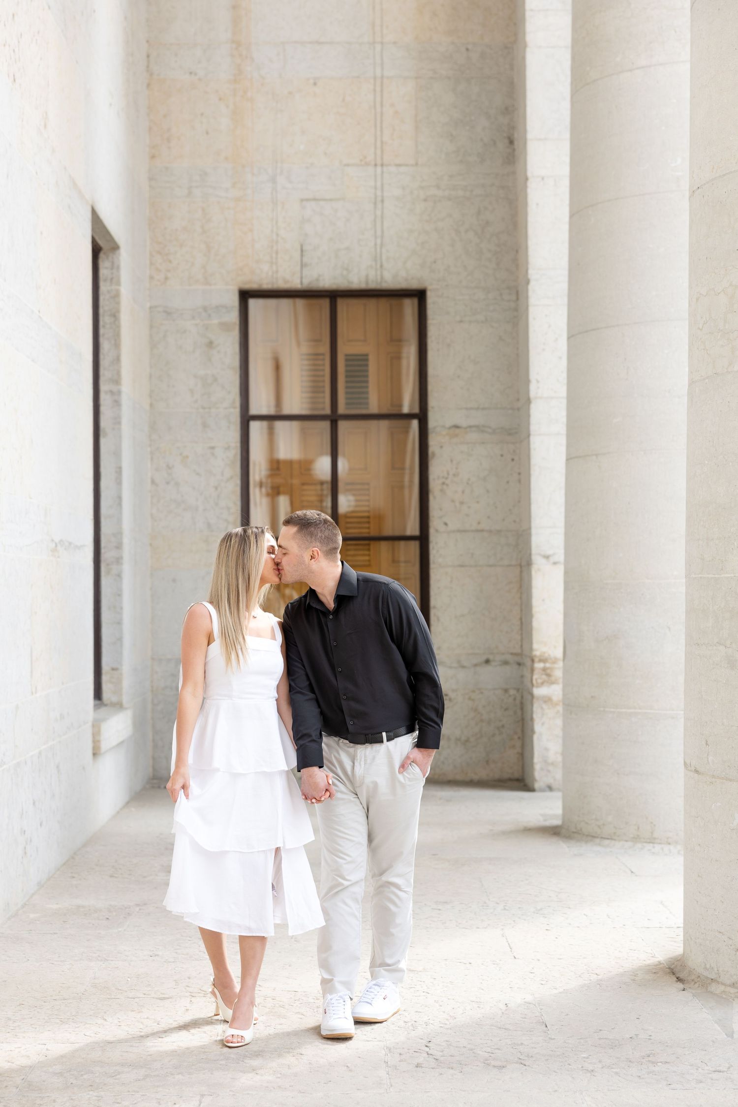 Light and airy engagement photos of a joyful couple at the Ohio Statehouse in downtown Columbus, Ohio captured by Julia and Sean Photography