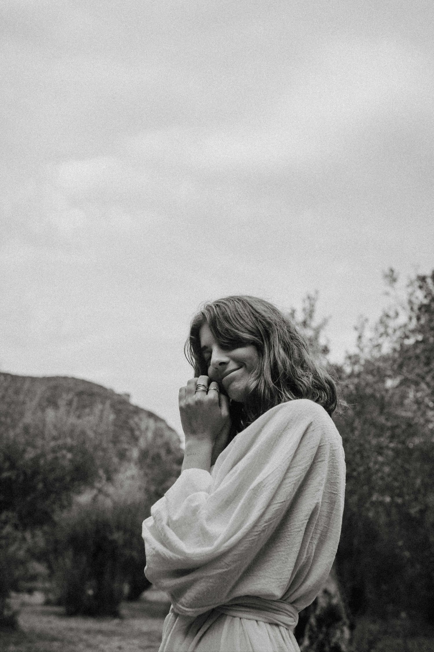 A candid black and white portrait outdoors with mountains in the background.