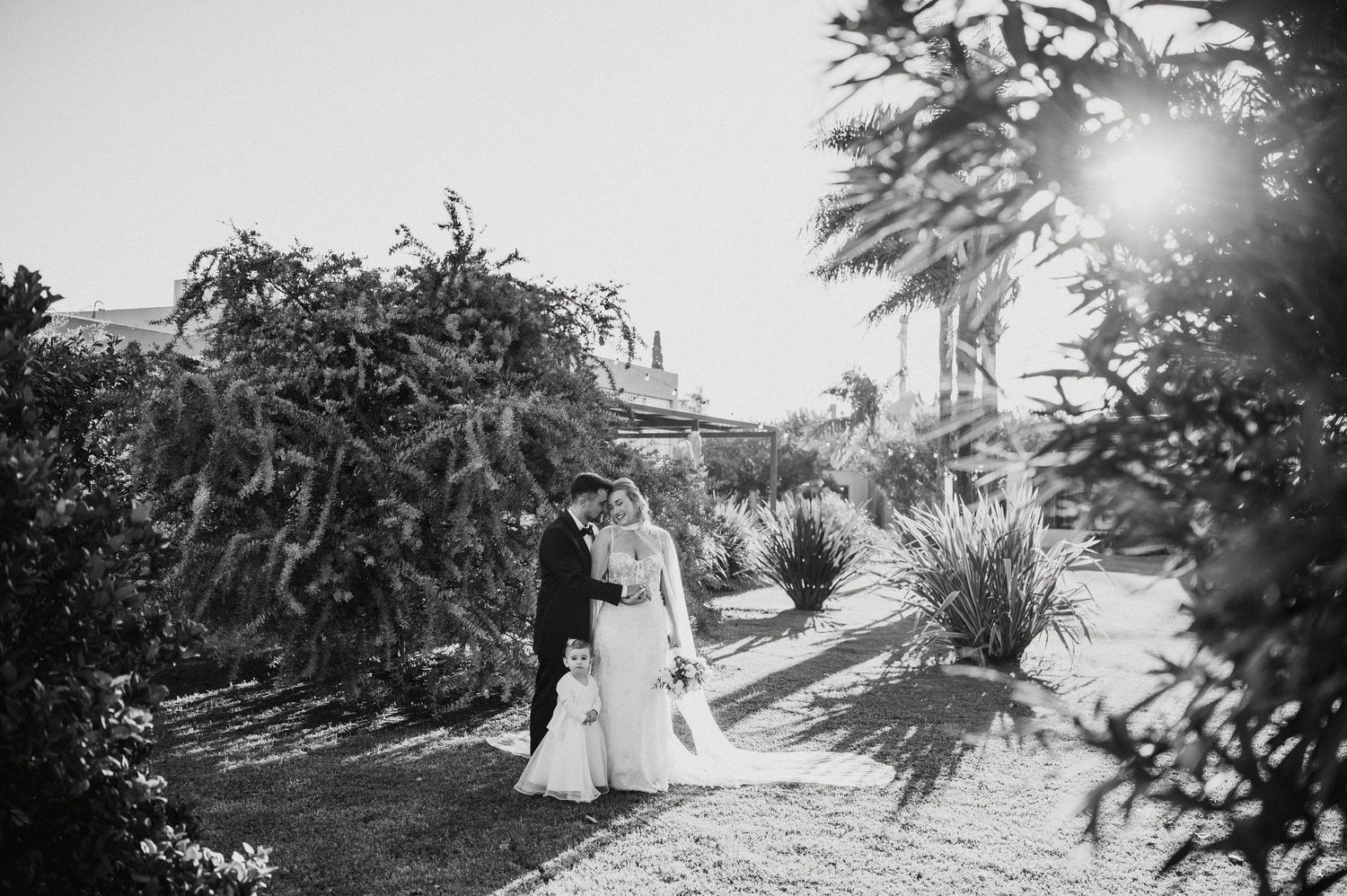 A romantic black and white wedding photoshoot sequence showing a couple walking together in a garden setting.