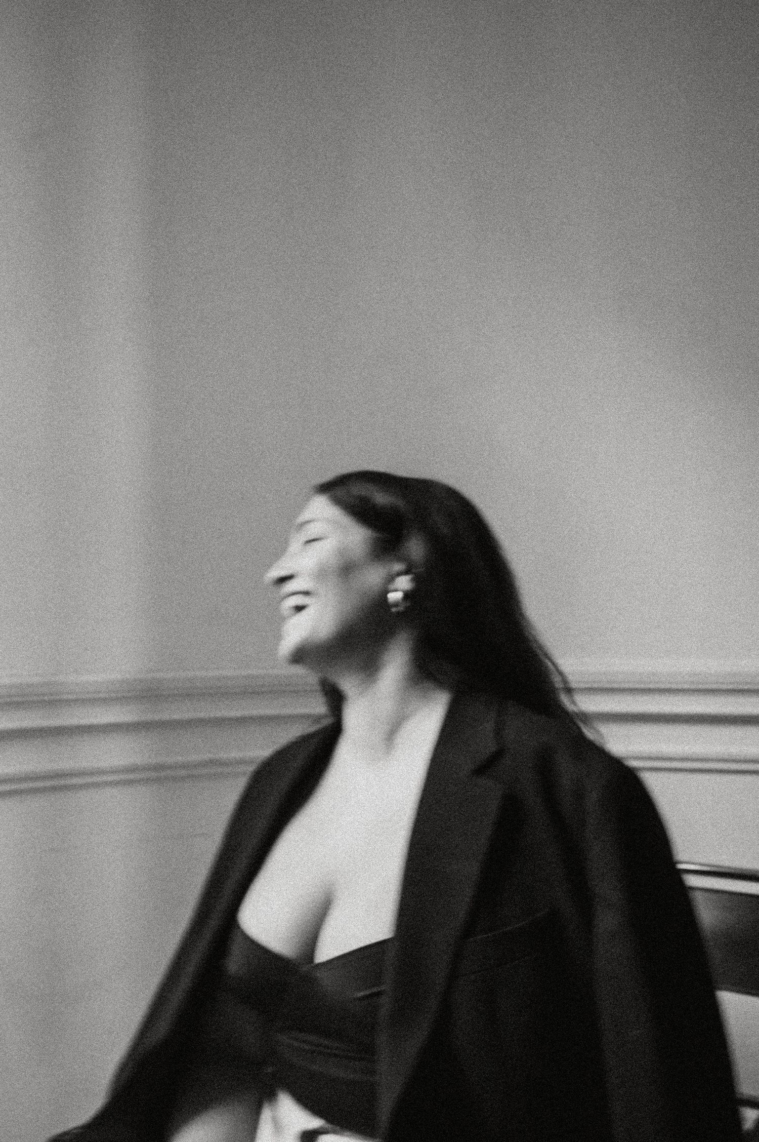 A black and white photo sequence shows a person in a dark blazer laughing and tilting their head back with joy.