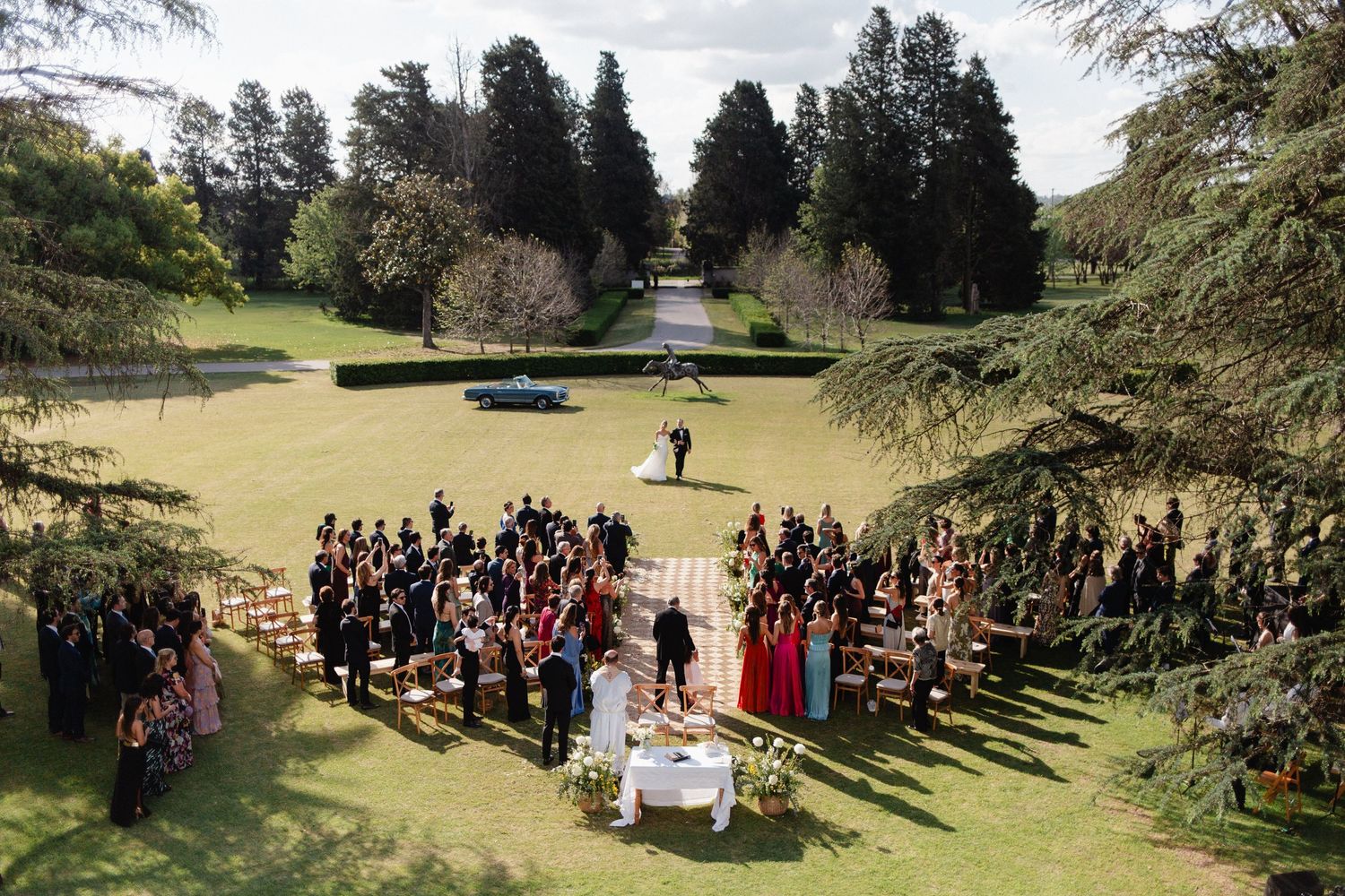 Outdoor wedding ceremony setup in a scenic park with rows of chairs and natural greenery creating a beautiful backdrop.